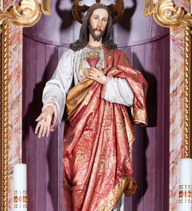 Zdjęcie nr 5: Ołtarz przyścienny, architektoniczny, jednoosiowy, jednokondygnacyjny. Mensa drewniana o formach wklęsło-wypukłych; na licu płycina w formie leżącego prostokąta o ściętych narożach wypełniona marmoryzacją. Tabernakulum dwudrzwiczkowe, zamknięte łukiem pełnym, ujęte dwiema  kolumienkami o kompozytowych kapitelach. W zwieńczeniu ażurowa, złocona dekoracja w formie przeciwstawnie ustawionego akantu z palmetą na osi. Na drzwiczkach płaskorzeźbione kłosy oraz winne grona. Retabulum na wysokim cokole ujęte ustawionymi ukośnie kolumnami o kompozytowych kapitelach i marmoryzowanych trzonach umiejscowionymi na wysokich postumentach (lica zdobione marmoryzowanymi płycinami  wypełnioymi rocaille'm). Podpory dźwigają odcinki pełnego, wyłamanego belkowania zwieńczonego wydatnym, silnie profilowanym gzymsem. Na belkowaniu, na osiach kolumn pełnoplastyczne figury niezidentyfikowanych świętych z krzyżem w ręku (z lewej, św. Jan Nepomucen?) oraz z księgą (z prawej). W polu centralnym nisza zamknięta u góry łukiem o falistym zarysie utworzonym przez dwie przeciwstawnie ustawione woluty. Nisza mieści pełnoplastyczną figurę Chrystusa z gorejącym sercem. Ponad nią, a osi dwie płaskorzeźbione uskrzydlone główki anielskie. Zwieńczenie o wolutowo wyciętych bokach zamknięte łukiem wklęsło-wypukłym. W polu płaskorzeźbione przedstawienie gorejącego serca w srebrzonym medalionie z obłoków oraz glorii promienistej o alternowanych promieniach. Powyżej na osi, pełnoplastyczna figura uskrzydlonego anioła. Po bokach wota i kampanule. Struktura malowana na kolor jasnobeżowy. Marmoryzacja w odcieniach różu. Ornamentyka oraz załamania profili architektonicznych złocone.