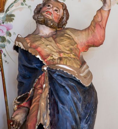 Zdjęcie nr 10: Ołtarz przyścienny, architektoniczny, trójosiowy. Mensa ołtarzowa skrzyniowa, prostopadłościenna z kamiennym portatylem, zamknięta profilowanym gzymsem podtrzymywanym przez cztery marmoryzowane kolumny. Antepedium dekorowane trzema płycinami: środkowa kwadratowa z krzyżem trójlistnym w czworoliściu, boczne  z aplikowanym motywem winorośli i kłosów zbóż. Retabulum ustawione na predelli, trójosiowe o półkoliście zamkniętych wnękach zakończonych trójkątnymi szczytami, w polu których uskrzydlone główki anielskie w medalionach. Wnęka środkowa wyższa i szersza zamknięta dwuspadowym daszkiem, ujęta parą kolumn kompozytowych wspierających odcinki gzymsu. Wewnątrz obraz z przedstawieniem  św. Rozalii. We wnękach bocznych pełnoplastyczne figury św. Piotra po lewej i św. Pawła po prawej stronie.  Nad wnęką środkową baldachim z figurą Chrystusa Zmartwychwstałego, po bokach pełnoplastyczne figury świętych. Predella dekorowana fryzem arkadkowym oraz płycinami z maswerkowaniem i rozetami, boki retabulum ujęte ażurowymi uszakami formowanymi z wici roślinnej. Półkoliste łuki wnęk zdobione arkadkami. Całość polichromowana na odcień ciemnobrązowy, detal architektoniczny i profilowania pomarańczowe oraz złocone. 