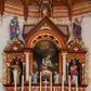 Zdjęcie nr 1: Ołtarz przyścienny, architektoniczny, trójosiowy. Mensa ołtarzowa skrzyniowa, prostopadłościenna z kamiennym portatylem, zamknięta profilowanym gzymsem podtrzymywanym przez cztery marmoryzowane kolumny. Antepedium dekorowane trzema płycinami: środkowa kwadratowa z krzyżem trójlistnym w czworoliściu, boczne  z aplikowanym motywem winorośli i kłosów zbóż. Retabulum ustawione na predelli, trójosiowe o półkoliście zamkniętych wnękach zakończonych trójkątnymi szczytami, w polu których uskrzydlone główki anielskie w medalionach. Wnęka środkowa wyższa i szersza zamknięta dwuspadowym daszkiem, ujęta parą kolumn kompozytowych wspierających odcinki gzymsu. Wewnątrz obraz z przedstawieniem  św. Rozalii. We wnękach bocznych pełnoplastyczne figury św. Piotra po lewej i św. Pawła po prawej stronie.  Nad wnęką środkową baldachim z figurą Chrystusa Zmartwychwstałego, po bokach pełnoplastyczne figury świętych. Predella dekorowana fryzem arkadkowym oraz płycinami z maswerkowaniem i rozetami, boki retabulum ujęte ażurowymi uszakami formowanymi z wici roślinnej. Półkoliste łuki wnęk zdobione arkadkami. Całość polichromowana na odcień ciemnobrązowy, detal architektoniczny i profilowania pomarańczowe oraz złocone. 