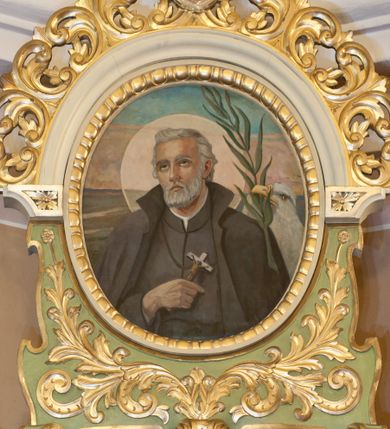 Zdjęcie nr 1: Obraz w kształcie owalu ukazujący św. Andrzeja Bobolę na tle rozległego, sumarycznie oddanego pejzażu. Święty przedstawiony w półpostaci, frontalnie z głową skierowaną w prawą stronę, z prawą ręką złożoną na piersi, w której trzyma krzyż. Twarz szeroka, okolona krótką i siwą brodą, oczy skierowane ku górze, wokół głowy kolisty, złoty nimb. Święty jest ubrany w czarny habit i płaszcz jezuicki. Po prawej stronie obrazu orzeł i palma męczeńska. Po lewej stronie znajduje się słabo widoczna sygnatura: „(?) Puchała / 1953/ (?)”. Rama dopasowana do kształtu malowidła, złocona, zdobiona kimationem.
