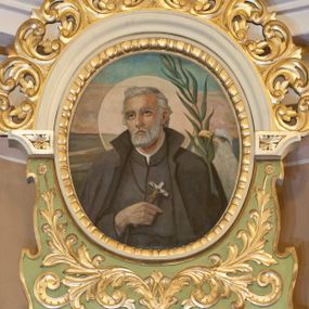 Zdjęcie nr 1: Obraz w kształcie owalu ukazujący św. Andrzeja Bobolę na tle rozległego, sumarycznie oddanego pejzażu. Święty przedstawiony w półpostaci, frontalnie z głową skierowaną w prawą stronę, z prawą ręką złożoną na piersi, w której trzyma krzyż. Twarz szeroka, okolona krótką i siwą brodą, oczy skierowane ku górze, wokół głowy kolisty, złoty nimb. Święty jest ubrany w czarny habit i płaszcz jezuicki. Po prawej stronie obrazu orzeł i palma męczeńska. Po lewej stronie znajduje się słabo widoczna sygnatura: „(?) Puchała / 1953/ (?)”. Rama dopasowana do kształtu malowidła, złocona, zdobiona kimationem.