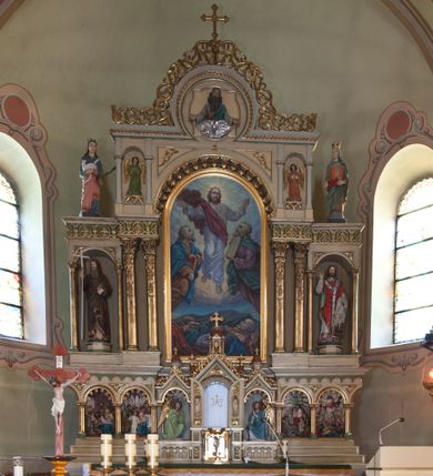 Zdjęcie nr 1: Nastawa ołtarzowa architektoniczna, trójosiowa, jednokondygnacyjna z predellą, ze zwieńczeniem, na cokole. Cokół dekorowany płycinami z arkadami, w których znajdują się biforia. Mensa kamienna z portatylem. Antepedium z płaskorzeźbioną sceną Ostatniej Wieczerzy w niszy ujętej arkadkami. Scena flankowana dwiema płycinami z ornamentem roślinnym, ujęta kolumnami w ściętych narożach. Tabernakulum trójosiowe w formie prostopadłościennej skrzynki z tronem wystawienia, rozbudowanym architektonicznie, ustawionym na niskim cokole dekorowanym arkadowaniem. Pośrodku tron wystawienia flankowany odwróconą parą odrzwi z figurami aniołów, z monogramem IHS w polu na białym tle, zamknięty trójkątnym przyczółkiem, na szczycie kopuła wsparta na wąskich kolumienkach zwieńczona krzyżykiem. W osiach bocznych arkady z figurami klęczących aniołów, zamknięte zwieńczeniem analogicznym jak w osi środkowej. Predella w formie arkadek z płaskorzeźbionymi scenami, od lewej: Narodzenie Chrystusa, Nauczanie w świątyni, Chrystus wśród dzieci i Zmartwychwstanie. Arkady predelli dekorowane krenelażem, w przyłuczach zdobione ornamentem roślinnym. Oś środkowa nastawy ołtarzowej ujęta dwiema parami kolumn dźwigającymi fryz i gzyms, na których opiera się półokrągły łuk flankowany przez dwie nisze z płaskorzeźbami aniołów. W polu środkowym obraz Przemienienie Pańskie. Trzony kolumn zdobione festonami. Osie boczne niższe, w formie arkad opartych na kolumnach, w których znajdują się figury po lewej św. Cyryla, a po prawej św. Metodego. Arkady dźwigają gzyms, na którym stoją figury, po lewej św. Agnieszki, a po prawej św. Elżbiety Węgierskiej. Zwieńczenie w formie medalionu z płaskorzeźbą Boga Ojca wśród obłoków z gołębicą Ducha Świętego. Całość obwiedziona astwerkiem. We fryzie ornament roślinno-geometryczny. Łuk pola obrazowego dekorowany palmetami, w przyłuczach ornament roślinny. Struktura polichromowana na kolor beżowy, detale na kolor jasnoszary i zielony, ornamentyka i detale złocone. 
