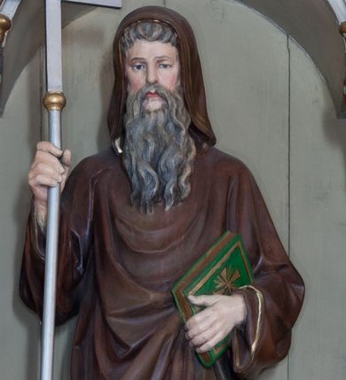 Zdjęcie nr 1: Rzeźba pełnoplastyczna przedstawiająca św. Cyryla, ustawiona na niskim cokole. Figura ustawiona frontalnie, w lewej ręce trzyma księgę, w prawej krzyż. Twarz pociągła, długi i szeroki nos, oczy skierowane na wprost, okolona bujną, siwą i długą brodą. Święty jest ubrany w brązową togę filozofa z długimi rękawami i kapturem założonym na głowę, obwiedzioną na brzegach stylizowaną wicią roślinną, pod spodem ma białą, długą suknię. Księga w zielonej obwolucie, z krzyżykiem greckim na okładce. Polichromia naturalistyczna w odsłoniętych partiach ciała, detale złocone i srebrzone.

