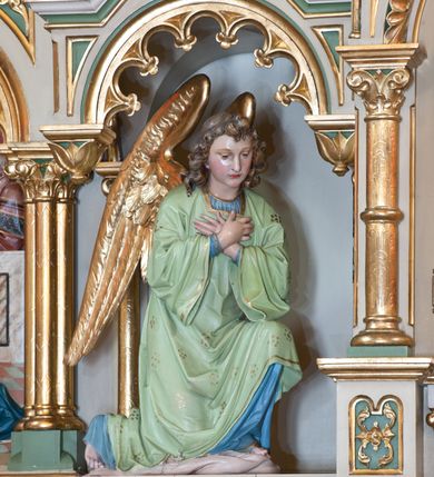 Zdjęcie nr 2: Tabernakulum trójosiowe w formie prostopadłościennej skrzynki z tronem wystawienia, rozbudowanym architektonicznie, ustawionym na niskim cokole dekorowanym arkadowaniem. Pośrodku tron wystawienia flankowany odwróconą parą odrzwi z figurami aniołów, z monogramem IHS w polu na białym tle, zamknięty trójkątnym przyczółkiem, na szczycie kopuła wsparta na wąskich kolumienkach zwieńczona krzyżykiem. W osiach bocznych arkady z figurami klęczących aniołów, zamknięte zwieńczeniem analogicznym jak w osi środkowej. Struktura polichromowana na kolor beżowy, detale na kolor jasnoszary i zielony, ornamentyka i detale złocone. 
