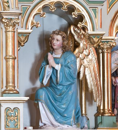 Zdjęcie nr 3: Tabernakulum trójosiowe w formie prostopadłościennej skrzynki z tronem wystawienia, rozbudowanym architektonicznie, ustawionym na niskim cokole dekorowanym arkadowaniem. Pośrodku tron wystawienia flankowany odwróconą parą odrzwi z figurami aniołów, z monogramem IHS w polu na białym tle, zamknięty trójkątnym przyczółkiem, na szczycie kopuła wsparta na wąskich kolumienkach zwieńczona krzyżykiem. W osiach bocznych arkady z figurami klęczących aniołów, zamknięte zwieńczeniem analogicznym jak w osi środkowej. Struktura polichromowana na kolor beżowy, detale na kolor jasnoszary i zielony, ornamentyka i detale złocone. 
