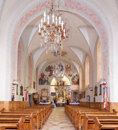 Zdjęcie nr 11: Kościół orientowany, murowany z cegły i kamienia, jednonawowy, na rzucie wydłużonego prostokąta z prezbiterium zamkniętym trójbocznie, wieżą na osi, zakrystią przy północnej ścianie prezbiterium, kruchtą przy południowej ścianie nawy i kaplicą od północy. Nawa pięcioprzęsłowa, ściany gładkie, sklepienie kolebkowe z lunetami, gurt między drugim, a trzecim przęsłem, pięć okien po stronie południowej, po północnej blendy odpowiadające wielkością i kształtem przeciwległym otworom okiennym. Prezbiterium oddzielone ścianą tęczową przeprutą łukiem o kształcie lekko zaostrzonym, dwuprzęsłowe, o sklepieniu krzyżowym, z dwoma ostrołukowymi oknami w ścianie południowej; zakrystia o sklepieniu sieciowym/gwiaździstym. Od zachodu chór wsparty arkadami z łukami o profilu lekko zaostrzonym, z balustradą zdobioną motywem rombu wypełnionego czworoliściem. Pod chórem skarbiec. Wejście główne od zachodu, boczne od południa z kruchtą (w nim kamienny portal z 1673 roku), kolejne od zakrystii, między zakrystią, a prezbiterium gotycki ostrołukowy portal z żelaznymi drzwiami z kratownicą rombową. 
Fasada wieżowa, z wejściem na osi po czterech stopniach. Przedsionek zwieńczony trójkątnym przyczółkiem z zatkniętym na szczycie krzyżem łacińskim. Drzwi zamknięte półkoliście, ponad nimi płaskorzeźba z przedstawieniem głowy Chrystusa otoczonej winną latoroślą. 
Wieża trójkondygnacyjna, zwieńczona trójkątnym przyczółkiem; w dolnej kondygnacji okulus, w środkowej okno zamknięte półkoliście, w ostatniej zegar w niszy powtarzającej kształt okna poniżej. 
Bryła rozczłonkowana; całość budynku obiega cokół, fragmentami kamienny, elewacje boczne oraz prezbiterium wsparte przyporami. Trzy przęsła nawy głównej otynkowane, reszta z cegły. Dachy dwuspadowe, nad pierwszymi dwoma przęsłami nawy niższy niż nad pozostałymi. Nad czwartym przęsłem nawy wieloboczna wieżyczka na sygnaturkę przepruta arkadami, przykryta dachem ostrosłupowym zakończonym kulą z krzyżem łacińskim.  
Do najcenniejszego wyposażenia kościoła należą: ołtarz główny z obrazem Ukrzyżowanego Chrystusa pędzla Jana Triciusa oraz słynący cudami obraz Matki Boskiej w ołtarzu bocznym. 
