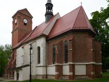 Zdjęcie nr 1: Kościół orientowany, murowany z cegły i kamienia, jednonawowy, na rzucie wydłużonego prostokąta z prezbiterium zamkniętym trójbocznie, wieżą na osi, zakrystią przy północnej ścianie prezbiterium, kruchtą przy południowej ścianie nawy i kaplicą od północy. Nawa pięcioprzęsłowa, ściany gładkie, sklepienie kolebkowe z lunetami, gurt między drugim, a trzecim przęsłem, pięć okien po stronie południowej, po północnej blendy odpowiadające wielkością i kształtem przeciwległym otworom okiennym. Prezbiterium oddzielone ścianą tęczową przeprutą łukiem o kształcie lekko zaostrzonym, dwuprzęsłowe, o sklepieniu krzyżowym, z dwoma ostrołukowymi oknami w ścianie południowej; zakrystia o sklepieniu sieciowym/gwiaździstym. Od zachodu chór wsparty arkadami z łukami o profilu lekko zaostrzonym, z balustradą zdobioną motywem rombu wypełnionego czworoliściem. Pod chórem skarbiec. Wejście główne od zachodu, boczne od południa z kruchtą (w nim kamienny portal z 1673 roku), kolejne od zakrystii, między zakrystią, a prezbiterium gotycki ostrołukowy portal z żelaznymi drzwiami z kratownicą rombową. 
Fasada wieżowa, z wejściem na osi po czterech stopniach. Przedsionek zwieńczony trójkątnym przyczółkiem z zatkniętym na szczycie krzyżem łacińskim. Drzwi zamknięte półkoliście, ponad nimi płaskorzeźba z przedstawieniem głowy Chrystusa otoczonej winną latoroślą. 
Wieża trójkondygnacyjna, zwieńczona trójkątnym przyczółkiem; w dolnej kondygnacji okulus, w środkowej okno zamknięte półkoliście, w ostatniej zegar w niszy powtarzającej kształt okna poniżej. 
Bryła rozczłonkowana; całość budynku obiega cokół, fragmentami kamienny, elewacje boczne oraz prezbiterium wsparte przyporami. Trzy przęsła nawy głównej otynkowane, reszta z cegły. Dachy dwuspadowe, nad pierwszymi dwoma przęsłami nawy niższy niż nad pozostałymi. Nad czwartym przęsłem nawy wieloboczna wieżyczka na sygnaturkę przepruta arkadami, przykryta dachem ostrosłupowym zakończonym kulą z krzyżem łacińskim.  
Do najcenniejszego wyposażenia kościoła należą: ołtarz główny z obrazem Ukrzyżowanego Chrystusa pędzla Jana Triciusa oraz słynący cudami obraz Matki Boskiej w ołtarzu bocznym. 
