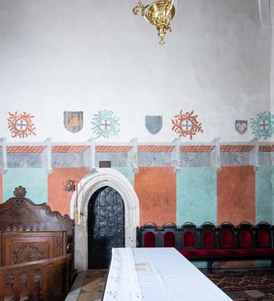 Zdjęcie nr 5: Kościół orientowany, murowany z cegły i kamienia, jednonawowy, na rzucie wydłużonego prostokąta z prezbiterium zamkniętym trójbocznie, wieżą na osi, zakrystią przy północnej ścianie prezbiterium, kruchtą przy południowej ścianie nawy i kaplicą od północy. Nawa pięcioprzęsłowa, ściany gładkie, sklepienie kolebkowe z lunetami, gurt między drugim, a trzecim przęsłem, pięć okien po stronie południowej, po północnej blendy odpowiadające wielkością i kształtem przeciwległym otworom okiennym. Prezbiterium oddzielone ścianą tęczową przeprutą łukiem o kształcie lekko zaostrzonym, dwuprzęsłowe, o sklepieniu krzyżowym, z dwoma ostrołukowymi oknami w ścianie południowej; zakrystia o sklepieniu sieciowym/gwiaździstym. Od zachodu chór wsparty arkadami z łukami o profilu lekko zaostrzonym, z balustradą zdobioną motywem rombu wypełnionego czworoliściem. Pod chórem skarbiec. Wejście główne od zachodu, boczne od południa z kruchtą (w nim kamienny portal z 1673 roku), kolejne od zakrystii, między zakrystią, a prezbiterium gotycki ostrołukowy portal z żelaznymi drzwiami z kratownicą rombową. 
Fasada wieżowa, z wejściem na osi po czterech stopniach. Przedsionek zwieńczony trójkątnym przyczółkiem z zatkniętym na szczycie krzyżem łacińskim. Drzwi zamknięte półkoliście, ponad nimi płaskorzeźba z przedstawieniem głowy Chrystusa otoczonej winną latoroślą. 
Wieża trójkondygnacyjna, zwieńczona trójkątnym przyczółkiem; w dolnej kondygnacji okulus, w środkowej okno zamknięte półkoliście, w ostatniej zegar w niszy powtarzającej kształt okna poniżej. 
Bryła rozczłonkowana; całość budynku obiega cokół, fragmentami kamienny, elewacje boczne oraz prezbiterium wsparte przyporami. Trzy przęsła nawy głównej otynkowane, reszta z cegły. Dachy dwuspadowe, nad pierwszymi dwoma przęsłami nawy niższy niż nad pozostałymi. Nad czwartym przęsłem nawy wieloboczna wieżyczka na sygnaturkę przepruta arkadami, przykryta dachem ostrosłupowym zakończonym kulą z krzyżem łacińskim.  
Do najcenniejszego wyposażenia kościoła należą: ołtarz główny z obrazem Ukrzyżowanego Chrystusa pędzla Jana Triciusa oraz słynący cudami obraz Matki Boskiej w ołtarzu bocznym. 
