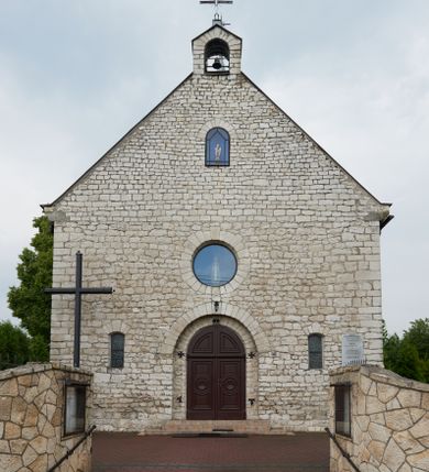 Zdjęcie nr 1: Kościół Najświętszej Marii Panny Królowej jest zlokalizowany w centrum Będkowic, na zachód od głównej drogi. Teren przykościelny jest otoczony wysokim murem posadowionym na kamiennej podmurówce oraz słupkach z nieregularnych ciosów kamienia i z żeliwnym płotem. W części wschodniej muru zlokalizowana jest szeroka brama, do której prowadzą schody, druga brama usytuowana jest nieco z prawej strony, również od wschodu.

Kościół jest skierowany na zachód, murowany, jednonawowy na rzucie prostokąta z prezbiterium zamkniętym półkoliście. Wnętrze tworzy szeroka nawa nakryta stropem oraz węższe i krótkie prezbiterium. Od północy przylega niewielka zakrystia na planie prostokąta z oknem od południa. Wejście do zakrystii zaznaczone jest drewnianym portalem. Na wschodniej ścianie nawy chór muzyczny, wsparty na dwóch słupach, dostępny klatką schodową od nawy. 

Nawę oświetlają dwa duże, rozglifione, prostokątne i zamknięte półkoliście okna umieszczone w południowej oraz północnej ścianie, a także dwa mniejsze okna ulokowane pod chórem zamknięte łukami odcinkowymi. Po bokach prezbiterium są dwa okrągłe okna. Wszystkie otwory okienne w nawie i prezbiterium wypełnione są witrażami lub ozdobnymi przeszkleniami. Do kościoła prowadzi główne wejście od strony wschodniej oraz jedno mniejsze od zakrystii.

Wygląd zewnętrznej elewacji kościoła jest skromny. Prezbiterium niższe od nawy, nad środkiem nawy wznosi się wieżyczka na sygnaturkę z latarnią, nakryta iglicą. Fasada prosta, w dolnej części wejście główne do świątyni, prostokątne, zamknięte łukiem półkolistym, powyżej okrągłe okno, a po bokach dwa mniejsze, prostokątne, zamknięte łukiem odcinkowym. W zwieńczeniu prostokątna, przeszklona, zamknięte półkoliście wnęka z figurą Chrystusa Frasobliwego, a na szczycie prosta aedikula z prześwitem, w której zawieszony jest mały dzwon. U góry łaciński krzyż na cokole. Otwory okienne i drzwiowe zdobione są kamienną okładziną. Świątynia nakryta jest dachem dwuspadowym.

