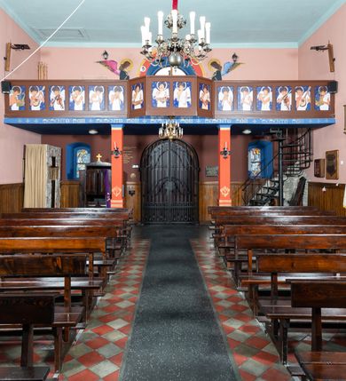 Zdjęcie nr 4: Kościół Najświętszej Marii Panny Królowej jest zlokalizowany w centrum Będkowic, na zachód od głównej drogi. Teren przykościelny jest otoczony wysokim murem posadowionym na kamiennej podmurówce oraz słupkach z nieregularnych ciosów kamienia i z żeliwnym płotem. W części wschodniej muru zlokalizowana jest szeroka brama, do której prowadzą schody, druga brama usytuowana jest nieco z prawej strony, również od wschodu.

Kościół jest skierowany na zachód, murowany, jednonawowy na rzucie prostokąta z prezbiterium zamkniętym półkoliście. Wnętrze tworzy szeroka nawa nakryta stropem oraz węższe i krótkie prezbiterium. Od północy przylega niewielka zakrystia na planie prostokąta z oknem od południa. Wejście do zakrystii zaznaczone jest drewnianym portalem. Na wschodniej ścianie nawy chór muzyczny, wsparty na dwóch słupach, dostępny klatką schodową od nawy. 

Nawę oświetlają dwa duże, rozglifione, prostokątne i zamknięte półkoliście okna umieszczone w południowej oraz północnej ścianie, a także dwa mniejsze okna ulokowane pod chórem zamknięte łukami odcinkowymi. Po bokach prezbiterium są dwa okrągłe okna. Wszystkie otwory okienne w nawie i prezbiterium wypełnione są witrażami lub ozdobnymi przeszkleniami. Do kościoła prowadzi główne wejście od strony wschodniej oraz jedno mniejsze od zakrystii.

Wygląd zewnętrznej elewacji kościoła jest skromny. Prezbiterium niższe od nawy, nad środkiem nawy wznosi się wieżyczka na sygnaturkę z latarnią, nakryta iglicą. Fasada prosta, w dolnej części wejście główne do świątyni, prostokątne, zamknięte łukiem półkolistym, powyżej okrągłe okno, a po bokach dwa mniejsze, prostokątne, zamknięte łukiem odcinkowym. W zwieńczeniu prostokątna, przeszklona, zamknięte półkoliście wnęka z figurą Chrystusa Frasobliwego, a na szczycie prosta aedikula z prześwitem, w której zawieszony jest mały dzwon. U góry łaciński krzyż na cokole. Otwory okienne i drzwiowe zdobione są kamienną okładziną. Świątynia nakryta jest dachem dwuspadowym.

