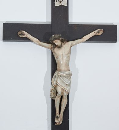 Zdjęcie nr 1: Chrystus przybity do krzyża trzema gwoździami. Figura w delikatnym zwisie, ramiona szeroko rozłożone, kolana silnie ugięte, stopy w układzie prawa na lewą. Twarz podłużna o długim nosie, oczy i usta zamknięte; okolona krótką brodą zakończoną dwoma puklami. Włosy długie, ciemnobrązowe, opadające na plecy i prawe ramię. Na głowie ciemnozielona korona cierniowa. Sylwetka szczupła z wyraźnie uwypukloną linią żeber klatki piersiowej i wąską talią. Ciało pokrywają liczne strużki krwi. Perizonium w formie tkaniny ściśle owijającej biodra, zawiązanej na prawym boku ze zwisem wzdłuż prawego uda. Nad głową Chrystusa biały, pionowy titulus w formie banderoli z napisem: „I(ESUS) N(AZARENUS) / R(EX) I(UDAEROUM)”. Krzyż gładki, malowany na kolor ciemnobrązowy. Polichromia naturalistyczna w odsłoniętych partiach ciała, perizonium białe ze złotą lamówką.