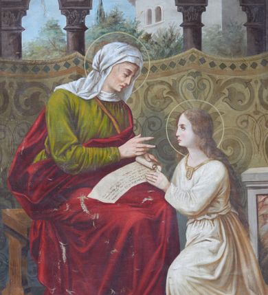 Zdjęcie nr 1: Obraz w kształcie stojącego prostokąta z przedstawieniem Nauczania Marii. W centrum kompozycji św. Anna ukazana w pozycji siedzącej, zwrócona trzy czwarte w lewo, która naucza klęczącą po prawej stronie obrazu Najświętszą Marię Pannę. Święta Anna jest delikatnie pochylona w stronę Marii, w lewej dłoni trzyma leżący na jej kolanach zwój Pisma Świętego. Święta ma podłużną twarz z długim nosem i dużymi oczami, ukazaną z prawego profilu. Ubrana jest w długą, zieloną suknię, czerwony płaszcz odsłaniający prawe ramię oraz biały welon na głowie. Maria zwrócona jest w prawo, ukazana z lewego profilu, klęczy na niebieskiej poduszce. Twarz o delikatnych rysach, okrągła o bladej karnacji, włosy długie i opadające na plecy. Maria ubrana jest w białą sukienkę, podwiązaną w pasie. Wokół głowy obu kobiet okrągłe nimby. Całość ukazana we wnętrzu architektonicznym na tle podwieszonej tapiserii, zdobionej dużymi wzorami ornamentalnymi. W oddali kolumnada, zielone drzewa i wysoki budynek. 


