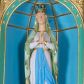 Zdjęcie nr 1: Rzeźba z przedstawieniem Matki Boskiej z Lourdes, ukazana frontalnie w postawie stojącej, z rękami złożonymi w geście modlitwy, z głową delikatnie uniesioną do góry. Matka Boska ubrana w jasnoróżową suknię, obwiedzioną na brzegach złotymi lamówkami, przewiązaną w talii złotym pasem z błękitną szarfą i jasnozielony płaszcz założony na głowę i spływający delikatnymi falami wzdłuż całej postaci, na brzegach obwiedziony złotą lamówką. Twarz owalna z długim i wąskim nosem, z wyraźnie zaznaczonym podbródkiem, ze wzrokiem skierowanym do góry, z zarumienionymi policzkami; na głowie korona w typie zamkniętym. Polichromia w odsłoniętych partiach ciała naturalistyczna.
