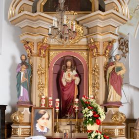 Zdjęcie nr 1: Ołtarz architektoniczny, jednokondygnacyjny, jednoosiowy, ze zwieńczeniem. Ołtarz drewniany, prostopadłościenny, z drewnianą mensą i kamiennym portatylem. Mensa ustawiona na niskim stopniu, na ściance frontowej zdobiona płyciną w kształcie leżącego prostokąta z płaskorzeźbionym monogramem IHS w polu. Nastawa ołtarzowa na zdwojonym cokole, ujęta parą ukośnie ustawionych filarów, podtrzymujących przerwane nad osią środkową belkowanie z silnie wysuniętym gzymsem i ukośnie ustawionym przerwanym, segmentowym przyczółkiem z usadzoną na nim parą aniołków. W polu środkowym głęboka, trójboczna wnęka, zamknięta półkoliście, z rzeźbą Najświętszego Serca Pana Jezusa, ujęta prostokątną, profilowaną ramą. Nad polem środkowym owalny kartusz z monogramem IHS na czerwonym polu, ujęty ornamentyką roślinną. Retabulum flankowane parą rzeźb: św. Piotra po prawej i św. Pawła po lewej stronie, ustawionych na wolutowych cokołach.

Zwieńczenie w kształcie stojącego prostokąta o uciętych bokach ujętych spływami wolutowymi, zamknięte gzymsem w formie łuku nadwieszonego, z ażurową, rocaille’ową dekoracją u szczytu; w polu obraz z przedstawieniem św. Barbary. Gzyms zdobiony rzędem stylizowanych palmetek. Trzony podpór zdobione dwiema, splecionymi gałązkami róży, spiętymi u góry karbowaną wstęgą; kapitele w formie konsolek w kształcie esownicy, zdobione ornamentyką stylizowanych akroterionów akantowych.

Struktura polichromowana w kolorze beżowym; wnęka i kapitele w kolorze różowym; ornamentyka i partie detalu architektonicznego złocone.    
