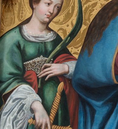 Zdjęcie nr 6: Obraz w kształcie stojącego prostokąta zamkniętego półkolistym łukiem nadwieszonym przedstawia całopostaciowy wizerunek Madonny z Dzieciątkiem w otoczeniu św. Małgorzaty i św. Katarzyny Aleksandryjskiej. Stojąca w wydatnym kontrapoście Maria nieznacznie zwrócona jest w trzech czwartych w lewo. Długie, falowane, jasnobrązowe włosy opadają na ramiona i plecy. Maria ubrana jest w jasnoczerwoną, spiętą w pasie suknię z lamowanym wykończeniem dekoltu z koronką oraz narzucony na ramiona, podwinięty pod prawą rękę i osłaniający prawą nogę niebieski płaszcz ze złoconym obszyciem. Pod jej stopami znajduje się sierp księżyca. Prawą dłonią wskazuje na podtrzymywane lewą ręką Dzieciątko Jezus w trzech czwartych zwrócone w prawo. Subtelną, o dziecięcych rysach twarz ujmują krótkie, kręcone włosy z pojedynczym puklem nad czołem. Jezus ubrany jest w długą, białą suknię, przewiązaną w pasie i z podobnym do sukni Marii wykończeiem dekoltu. W prawej, nieznacznie uniesionej ręce trzyma jabłko, lewą, lekko zgiętą w łokciu, opuszcza wzdłuż ciała. Po prawej stronie Madonny stoi w kontrapoście, zwrócona w trzech czwartych w prawo św. Małgorzata. Długie, jasnobrązowe włosy opadają na plecy. Święta ubrana jest w długą, czerwoną suknię częściowo obszytą perłami, z odciętym gorsetem o kwadratowym dekolcie i krótkich, szerokich rękawach, spod których widoczna jest biała koszula o obszernych, bufiastych rękawach i wąskich mankietach. Plecy osłania długi, zielony płaszcz, którego poła wsunięta jest pod lewą, opuszczoną wzdłuż ciała ręką. W prawej, wspartej na piersiach święta trzyma niewielki krzyż. Pod jej stopami znajduje się sylwetka spoglądającego do góry smoka z obrożą na szyi, której łańcuch święta trzyma w lewej dłoni. Tuż nad lewym ramieniem św. Małgorzaty unosi się biały gołąb. Po lewej stronie Madonny stoi w kontrapoście św. Katarzyna Aleksandryjska zwrócona w trzech czwartych lewo. Zaczesane do tyłu długie włosy opadają na plecy. Święta ubrana jest w jasnofioletową spódnicę i białą koszulę której obszerny kołnierz i szeroki rękaw z wąskim mankietem widoczne są spod sięgającej kolan, zielonej sukni o podsuniętych, szerokich rękawach i bogato kameryzowanym gorsecie. Rękami podtrzymuje zsuwający się z pleców czerwony płaszcz. W lewej, uniesionej na wysokości talii ręce trzyma gałązkę palmową, prawą, opuszczoną w dół podtrzymuje wsparty na podłożu miecz. U stóp świętej leży fragment złamanego koła. Owalne twarze Marii i świętych charakteryzuje jasna karnacja, delikatny modelunek, subtelne, młodzieńcze rysy oraz lekko zaróżowione policzki. Głowę Madonny i Dzieciątka wieńczą zamknięte korony, a świętych – korony w typie otwartym; wszystkie są kameryzowane. W górnej partii przedstawienia unosi się para ubranych w jasnoróżowe sukienki aniołów nakładających koronę na głowę Marii i  trzymających w dłoniach gałązki palmowe. Tło przedstawienia jest złocone z rytą dekoracją w formie ornamentyki roślinnej, głowy świętych, Marii i Dzieciątka okalają nimby, natomiast u góry kompozycji widoczny jest fragment tarczy słonecznej.      