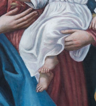 Zdjęcie nr 5: Obraz w kształcie stojącego prostokąta zamkniętego półkolistym łukiem nadwieszonym przedstawia całopostaciowy wizerunek Madonny z Dzieciątkiem w otoczeniu św. Małgorzaty i św. Katarzyny Aleksandryjskiej. Stojąca w wydatnym kontrapoście Maria nieznacznie zwrócona jest w trzech czwartych w lewo. Długie, falowane, jasnobrązowe włosy opadają na ramiona i plecy. Maria ubrana jest w jasnoczerwoną, spiętą w pasie suknię z lamowanym wykończeniem dekoltu z koronką oraz narzucony na ramiona, podwinięty pod prawą rękę i osłaniający prawą nogę niebieski płaszcz ze złoconym obszyciem. Pod jej stopami znajduje się sierp księżyca. Prawą dłonią wskazuje na podtrzymywane lewą ręką Dzieciątko Jezus w trzech czwartych zwrócone w prawo. Subtelną, o dziecięcych rysach twarz ujmują krótkie, kręcone włosy z pojedynczym puklem nad czołem. Jezus ubrany jest w długą, białą suknię, przewiązaną w pasie i z podobnym do sukni Marii wykończeiem dekoltu. W prawej, nieznacznie uniesionej ręce trzyma jabłko, lewą, lekko zgiętą w łokciu, opuszcza wzdłuż ciała. Po prawej stronie Madonny stoi w kontrapoście, zwrócona w trzech czwartych w prawo św. Małgorzata. Długie, jasnobrązowe włosy opadają na plecy. Święta ubrana jest w długą, czerwoną suknię częściowo obszytą perłami, z odciętym gorsetem o kwadratowym dekolcie i krótkich, szerokich rękawach, spod których widoczna jest biała koszula o obszernych, bufiastych rękawach i wąskich mankietach. Plecy osłania długi, zielony płaszcz, którego poła wsunięta jest pod lewą, opuszczoną wzdłuż ciała ręką. W prawej, wspartej na piersiach święta trzyma niewielki krzyż. Pod jej stopami znajduje się sylwetka spoglądającego do góry smoka z obrożą na szyi, której łańcuch święta trzyma w lewej dłoni. Tuż nad lewym ramieniem św. Małgorzaty unosi się biały gołąb. Po lewej stronie Madonny stoi w kontrapoście św. Katarzyna Aleksandryjska zwrócona w trzech czwartych lewo. Zaczesane do tyłu długie włosy opadają na plecy. Święta ubrana jest w jasnofioletową spódnicę i białą koszulę której obszerny kołnierz i szeroki rękaw z wąskim mankietem widoczne są spod sięgającej kolan, zielonej sukni o podsuniętych, szerokich rękawach i bogato kameryzowanym gorsecie. Rękami podtrzymuje zsuwający się z pleców czerwony płaszcz. W lewej, uniesionej na wysokości talii ręce trzyma gałązkę palmową, prawą, opuszczoną w dół podtrzymuje wsparty na podłożu miecz. U stóp świętej leży fragment złamanego koła. Owalne twarze Marii i świętych charakteryzuje jasna karnacja, delikatny modelunek, subtelne, młodzieńcze rysy oraz lekko zaróżowione policzki. Głowę Madonny i Dzieciątka wieńczą zamknięte korony, a świętych – korony w typie otwartym; wszystkie są kameryzowane. W górnej partii przedstawienia unosi się para ubranych w jasnoróżowe sukienki aniołów nakładających koronę na głowę Marii i  trzymających w dłoniach gałązki palmowe. Tło przedstawienia jest złocone z rytą dekoracją w formie ornamentyki roślinnej, głowy świętych, Marii i Dzieciątka okalają nimby, natomiast u góry kompozycji widoczny jest fragment tarczy słonecznej.      