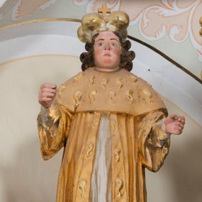 Zdjęcie nr 1: Całopostaciowa, drążona z tyłu figura św. Kazimierza stojącego w układzie frontalnym na niewielkim, prostopadłościennym postumencie. Owalną twarz charakteryzują sumarycznie opracowane rysy z krótkim, zaokrąglonym nosem, szeroko rozstawionymi oczami oraz podkreślonymi rumieńcem policzkami, czubkiem nosa oraz brodą. Na barki opadają skręcone w wydatne pukle, brązowe włosy. Święty ubrany jest w strój książęcy składający się z długiej, srebrzonej sukni oraz złoconego płaszcza z szerokimi rękawami i gronostajowym obszyciem, na który nałożona jest gronostajowa peleryna. Na głowie ma mitrę książęcą z wydatnym krzyżem. W zgiętych w łokciach, wyciągniętych przed siebie rękach pierwotnie znajdowały się niezachowane atrybuty.   

