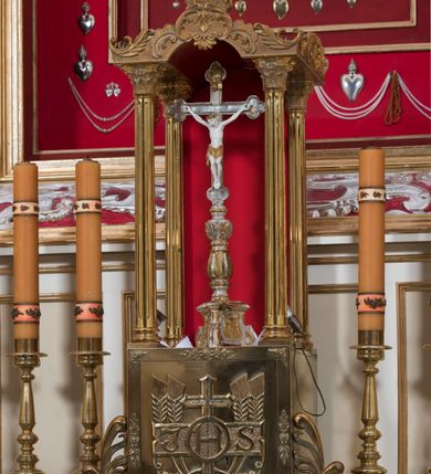 Zdjęcie nr 32: Ołtarz architektoniczny, dwukondygnacyjny, trójosiowy, ze zwieńczeniem. Ołtarz murowany, prostopadłościenny z marmurowym antepedium. Tabernakulum w formie prostopadłościennej, metalowej szafki ujętej parą ażurowych spływów wolutowych w formie stylizowanych wici akantowych. Drzwiczki, w kształcie zbliżonym do kwadratu, zdobione motywem krzyża i banderoli z napisem „IHS” ujętych kłosami zboża i kiściami winnej latorośli. Tron wystawienia w formie baldachimu wspartego na 4 kolumienkach. Krawędź zwieńczenia ujęta jest ornamentyką roślinną, w motywem kartusza z krzyżem po środku. Oś środkowa retabulum osadzona na wysokim, zdwojonym cokole o zryzalitowanych bokach. Pierwszą kondygnację ujmują dwie pary kolumn o kanelowanych trzonach i korynckich kapitelach, z czego wewnętrzne wysunięte względem lica nastawy, wspierających wyłamujące się ponad nimi belkowanie, w partii architrawu przybierające kształt  półkolistego łuku nadwieszonego; całość wieńczy forma trójkątnego przyczółka. Druga kondygnacja ujęta parą osadzonych na cokołach kolumn o trzonach zdobionych wicią winnej latorośli, wspierających delikatnie wyłamujące się ponad nimi belkowanie przerwane w partii fryzu u gzymsu. Zwieńczenie w formie trójkątnego, przerwanego przyczółka. W strefie zryzalitowanych po bokach cokołów osi bocznych para półkoliście zamkniętych bramek. Krawędzie zewnętrzne kondygnacji osi bocznych ujęte pojedynczymi kolumnami dźwigającymi wyłamujące się ponad nimi belkowanie wieńczące, będące przedłużeniem belkowania osi środkowej.  Pola cokołu retabulum wypełnione motywami ornamentyki roślinnej, w partii fryzu motywy małżowinowo-chrząstkowe. Druga kondygnacja osi środkowej ujęta parą ażurowych, małżowinowo-chrząstkowych uszaków, szczyt zwieńczenia w formie promienistej glorii z owalnym medalionem ujętym wieńcem obłoków, z monogramem imienia Jezus. Pola osi bocznych w dolnej partii zdobione motywami małżowinowo-chrząstkowego kartusza, w górnej owocowo-kwiatowymi festonami. Skrajne pola cokołu retabulum wypełnia para wizerunków – św. Pawła po prawej stronie i św. Piotra po lewej. Pole pierwszej kondygnacji osi środkowej ma formę płytkiej wnęki w kształcie stojącego prostokąta zamkniętego półkolistym łukiem nadwieszonym, ujętej bogato rzeźbioną ramą z motywem ornamentu małżowinowo-chrząstkowego, w środku obraz Matki Boskiej z Dzieciątkiem. Pole drugiej kondygnacji wypełnia obraz w kształcie leżącego prostokąta, ujęty szeroką ramą z uszakami w narożach, zdobioną ornamentem małżowinowo-chrząstkowym. Po bokach para półkoliście zamkniętych niszy z motywem konchy, wypełnionych parą figur – po prawej stronie św. Dominika, po lewej św. Antoni (?). Pola osi bocznych artykułuje para zamkniętych półkoliście niszy z motywami konchy, z parą rzeźb – św. Stanisława po prawej stronie i św. Wojciecha po lewej.  W szczycie osi bocznych pośrodku para rzeźb flankujących zwieńczenie ołtarza – po prawej stronie św. Wacława, po lewej św. Kazimierza, na końcach para figur aniołów. Struktura polichromowana w odcieniach koloru kremowego i beżowego, detal architektoniczny i ornamentyka złocone i srebrzone.