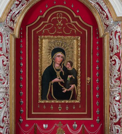 Zdjęcie nr 13: Ołtarz architektoniczny, dwukondygnacyjny, trójosiowy, ze zwieńczeniem. Ołtarz murowany, prostopadłościenny z marmurowym antepedium. Tabernakulum w formie prostopadłościennej, metalowej szafki ujętej parą ażurowych spływów wolutowych w formie stylizowanych wici akantowych. Drzwiczki, w kształcie zbliżonym do kwadratu, zdobione motywem krzyża i banderoli z napisem „IHS” ujętych kłosami zboża i kiściami winnej latorośli. Tron wystawienia w formie baldachimu wspartego na 4 kolumienkach. Krawędź zwieńczenia ujęta jest ornamentyką roślinną, w motywem kartusza z krzyżem po środku. Oś środkowa retabulum osadzona na wysokim, zdwojonym cokole o zryzalitowanych bokach. Pierwszą kondygnację ujmują dwie pary kolumn o kanelowanych trzonach i korynckich kapitelach, z czego wewnętrzne wysunięte względem lica nastawy, wspierających wyłamujące się ponad nimi belkowanie, w partii architrawu przybierające kształt  półkolistego łuku nadwieszonego; całość wieńczy forma trójkątnego przyczółka. Druga kondygnacja ujęta parą osadzonych na cokołach kolumn o trzonach zdobionych wicią winnej latorośli, wspierających delikatnie wyłamujące się ponad nimi belkowanie przerwane w partii fryzu u gzymsu. Zwieńczenie w formie trójkątnego, przerwanego przyczółka. W strefie zryzalitowanych po bokach cokołów osi bocznych para półkoliście zamkniętych bramek. Krawędzie zewnętrzne kondygnacji osi bocznych ujęte pojedynczymi kolumnami dźwigającymi wyłamujące się ponad nimi belkowanie wieńczące, będące przedłużeniem belkowania osi środkowej.  Pola cokołu retabulum wypełnione motywami ornamentyki roślinnej, w partii fryzu motywy małżowinowo-chrząstkowe. Druga kondygnacja osi środkowej ujęta parą ażurowych, małżowinowo-chrząstkowych uszaków, szczyt zwieńczenia w formie promienistej glorii z owalnym medalionem ujętym wieńcem obłoków, z monogramem imienia Jezus. Pola osi bocznych w dolnej partii zdobione motywami małżowinowo-chrząstkowego kartusza, w górnej owocowo-kwiatowymi festonami. Skrajne pola cokołu retabulum wypełnia para wizerunków – św. Pawła po prawej stronie i św. Piotra po lewej. Pole pierwszej kondygnacji osi środkowej ma formę płytkiej wnęki w kształcie stojącego prostokąta zamkniętego półkolistym łukiem nadwieszonym, ujętej bogato rzeźbioną ramą z motywem ornamentu małżowinowo-chrząstkowego, w środku obraz Matki Boskiej z Dzieciątkiem. Pole drugiej kondygnacji wypełnia obraz w kształcie leżącego prostokąta, ujęty szeroką ramą z uszakami w narożach, zdobioną ornamentem małżowinowo-chrząstkowym. Po bokach para półkoliście zamkniętych niszy z motywem konchy, wypełnionych parą figur – po prawej stronie św. Dominika, po lewej św. Antoni (?). Pola osi bocznych artykułuje para zamkniętych półkoliście niszy z motywami konchy, z parą rzeźb – św. Stanisława po prawej stronie i św. Wojciecha po lewej.  W szczycie osi bocznych pośrodku para rzeźb flankujących zwieńczenie ołtarza – po prawej stronie św. Wacława, po lewej św. Kazimierza, na końcach para figur aniołów. Struktura polichromowana w odcieniach koloru kremowego i beżowego, detal architektoniczny i ornamentyka złocone i srebrzone.