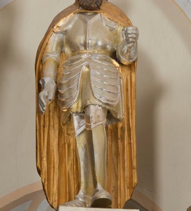 Zdjęcie nr 20: Ołtarz architektoniczny, dwukondygnacyjny, trójosiowy, ze zwieńczeniem. Ołtarz murowany, prostopadłościenny z marmurowym antepedium. Tabernakulum w formie prostopadłościennej, metalowej szafki ujętej parą ażurowych spływów wolutowych w formie stylizowanych wici akantowych. Drzwiczki, w kształcie zbliżonym do kwadratu, zdobione motywem krzyża i banderoli z napisem „IHS” ujętych kłosami zboża i kiściami winnej latorośli. Tron wystawienia w formie baldachimu wspartego na 4 kolumienkach. Krawędź zwieńczenia ujęta jest ornamentyką roślinną, w motywem kartusza z krzyżem po środku. Oś środkowa retabulum osadzona na wysokim, zdwojonym cokole o zryzalitowanych bokach. Pierwszą kondygnację ujmują dwie pary kolumn o kanelowanych trzonach i korynckich kapitelach, z czego wewnętrzne wysunięte względem lica nastawy, wspierających wyłamujące się ponad nimi belkowanie, w partii architrawu przybierające kształt  półkolistego łuku nadwieszonego; całość wieńczy forma trójkątnego przyczółka. Druga kondygnacja ujęta parą osadzonych na cokołach kolumn o trzonach zdobionych wicią winnej latorośli, wspierających delikatnie wyłamujące się ponad nimi belkowanie przerwane w partii fryzu u gzymsu. Zwieńczenie w formie trójkątnego, przerwanego przyczółka. W strefie zryzalitowanych po bokach cokołów osi bocznych para półkoliście zamkniętych bramek. Krawędzie zewnętrzne kondygnacji osi bocznych ujęte pojedynczymi kolumnami dźwigającymi wyłamujące się ponad nimi belkowanie wieńczące, będące przedłużeniem belkowania osi środkowej.  Pola cokołu retabulum wypełnione motywami ornamentyki roślinnej, w partii fryzu motywy małżowinowo-chrząstkowe. Druga kondygnacja osi środkowej ujęta parą ażurowych, małżowinowo-chrząstkowych uszaków, szczyt zwieńczenia w formie promienistej glorii z owalnym medalionem ujętym wieńcem obłoków, z monogramem imienia Jezus. Pola osi bocznych w dolnej partii zdobione motywami małżowinowo-chrząstkowego kartusza, w górnej owocowo-kwiatowymi festonami. Skrajne pola cokołu retabulum wypełnia para wizerunków – św. Pawła po prawej stronie i św. Piotra po lewej. Pole pierwszej kondygnacji osi środkowej ma formę płytkiej wnęki w kształcie stojącego prostokąta zamkniętego półkolistym łukiem nadwieszonym, ujętej bogato rzeźbioną ramą z motywem ornamentu małżowinowo-chrząstkowego, w środku obraz Matki Boskiej z Dzieciątkiem. Pole drugiej kondygnacji wypełnia obraz w kształcie leżącego prostokąta, ujęty szeroką ramą z uszakami w narożach, zdobioną ornamentem małżowinowo-chrząstkowym. Po bokach para półkoliście zamkniętych niszy z motywem konchy, wypełnionych parą figur – po prawej stronie św. Dominika, po lewej św. Antoni (?). Pola osi bocznych artykułuje para zamkniętych półkoliście niszy z motywami konchy, z parą rzeźb – św. Stanisława po prawej stronie i św. Wojciecha po lewej.  W szczycie osi bocznych pośrodku para rzeźb flankujących zwieńczenie ołtarza – po prawej stronie św. Wacława, po lewej św. Kazimierza, na końcach para figur aniołów. Struktura polichromowana w odcieniach koloru kremowego i beżowego, detal architektoniczny i ornamentyka złocone i srebrzone.