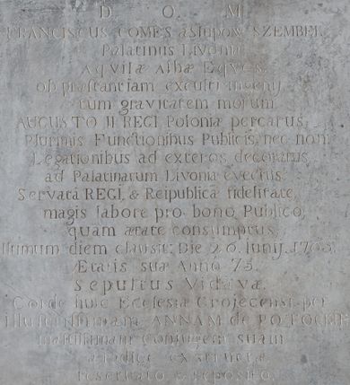 Zdjęcie nr 1: Przyścienne epitafium uzyskało kształt prostokątnej tablicy z majuskułową łacińską inskrypcją, ujętej rozbudowaną ramą, w obramieniu utworzonego z ornamentu rollwerkowego. Na ramie występują płaskorzeźbione panoplia, m.in. tarcza, hełm rycerski, skrzyżowane szable, łuk i kołczan ze strzałami, proporce, armaty, beczka na proch i inne. W zwieńczeniu umieszczono owalny kartusz herbowy zwieńczony krzyżem o trójlistnie zakończonych ramionach. W jego polu wpisano herb Kornicz umieszczony na tarczy z labrami, hełmem i klejnotem. Kartusz flankują antytetycznie ustawione woluty, na których ustawiono wazony. Pod tablicą  na osi także umieszczono owalny kartusz wypełniony herbem Trąby, ujęty po bokach wolutami.