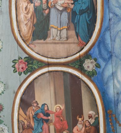 Zdjęcie nr 25: Ściany kościoła pokrywa dekoracja dywanowa, której w partiach stropu towarzyszą przedstawienia figuralne. W prezbiterium wykonano wyraźnie zaakcentowany fryz podstropowy, który od fasety oddziela profilowany i ornamentalnie malowany gzyms. Fryz na baldoniebieskim tle pokryto naprzemiennie rozmieszczonymi uskrzydlonymi główkami aniołów z niskimi wazonami z rozłożonymi trzema gałązkami kwitnących lilii. Poniżej barwnej bordiury oddzielającej fryz od pozostałych partii ścian, wykonano zgeometryzowaną dekorację utworzoną z powtarzających się wielobocznych pól, w których znalazł się stylizowany motyw tego samego kwiatu. Fasetę w prezbiterium pokryto naprzemiennie, rytmicznie rozmieszczonymi stylizowanymi kwiatami na łodydze i bez łodygi, które obwiedziono migdałowymi otokami tworzą ornamentalny pas zamknięty u góry falującą, wąską bordiurą. Dekorację bladoniebieskiego stropu prezbiterium tworzy poprowadzona przy krawędziach srebrno-niebieska arkatura. W centrum na niebieskim tle usianym złotymi gwiazdkami wyobrażono zasiadającą na obłokach Trójcę Świętą obramienioną pofalowaną, wielobarwną bordiurą otoczoną stylizowaną, srebrną wicią akantową. Dekoracyjną wić przedzielono parą uskrzydlonych główek anielskich oraz czterema stylizowanymi pąkami fantazyjnych kwiatów. Frontalnie ujęty Bóg Ojciec został wyobrażony jako siwobrody starzec o bujnych siwych włosach. W prawej ręce trzyma złote berło, lewą zaś wyciąga przed siebie. Bóg Ojciec prawą nogę opiera o niebieski glob, natomiast lewą, wyprostowaną wspiera się o obłoki. Jego twarz charakteryzuje jasna karnacja, szeroko otwarte oczy, wydatny nos i usta. Wokół głowy widać trójkąt. Obok Boga Ojca z lewej strony siedzi Chrystus, który obie nogi wspiera na globie. Zbawiciel trzymający oburącz na wysokości ramienia drewniany krzyż został przedstawiony w trzech czwartych w prawo. Jest to dojrzały mężczyzna o pociągłej twarzy okolonej brązowymi, długimi włosami spływającymi na ramiona oraz brodą. Ma jasną karnację, prosty nos i wydatne usta. Jego melancholijne spojrzenie jest skierowane w bok. Nagi tors okrywa bladoszkarłatny płaszcz odsłaniający prawą nogę. Na dłoniach i stopach widoczne są rany po gwoździach. Głowę Jezusa okala świetlisty nimb. Powyżej obu postaci unosi się gołębica Ducha Świętego w promienistym otoku. Niebieski glob na tle obłoków unoszą dwa aniołki w przepaskach. W nawie kościoła dekorację tworzą trzy różnej szerokości poziome pasy ornamentalne ułożone ponad jednolitą, szarą lamperią. Najszerszy pas pokryto na jasnym tle zgeometryzowanym ornamentem utworzonym z ciemnocynobrowych, migdałowo kształtowanych pól naśladujących wić roślinną. Powyżej rozmieszczono rytmicznie ułożone stylizowane krzyże równoramienne w fantazyjnych, wielobarwnych obramieniach. Najwyższy pas, odpowiadający fryzowi podstropowemu w prezbiterium pokryto wicią winnej latorośli z wplecionymi pękami kłosów. Tą część dekoracji zamyka profilowany gzyms ozdobiony wielobarwnym ornamentem zgeomertyzowanym. Rozpościerającą się ponad nim fasetę ozdobiono rytmicznie rozmieszczonym białym kwiatem na łodydze naśladujący w kształcie grzebień wodny. Dekorację bladoniebieskiego stropu artykułowano za pomocą srebrnej arkatury poprowadzonej przy jego krawędziach oraz ornamentalnych pasów utworzonych z motywów floralnych i geometrycznych, tworzących czworoboczną ramę dla centralnej kompozycji figuralnej. W narożach tego obramienia umieszczono medaliony ukazujące w popiersiach czterech ewangelistów malowanych na blasze miedzianej. Medaliony otaczają stylizowane gałązki dębowe z żołędziami. Każdego ewangelistę identyfikuje jego atrybut. W centrum stropu na bladozielonym tle usianym srebrnymi gwiazdkami namalowano wydłużone owalne obramienie utworzone z szerokiego wieńca różanego o bardzo drobnych kwiatach różanych i listkach. W jego centrum na tle bladoniebieskich obłoków ze złotymi gwiazdkami, bezpośrednio na deskach stropu, przedstawiono stojącą Madonnę z Dzieciątkiem, która depcze węża. Dodatkowo postać Marii zdaje się stać na rozpiętym różańcu. Maria ujęta frontalnie w kontrapoście obiema rękami podtrzymuje na prawym ramieniu Dzieciątko. Ma pociągłą twarz o jasnej karnacji, prostym nosie i wąskich ustach. Spojrzenie jej przymkniętych oczu jest skierowane w dół. Na głowie ma chustę szczelnie okrywającą jej włosy oraz złotą koronę o niskich sterczynach. Madonna ubrana jest w bladoczerwoną suknię odsłaniającą bosą stopę, którą depcze węża. Spod sukni na piersi widać białą koszulę. Na ramionach ma błękitny płaszcz podbity jasną ochrą, spięty na piersi podłużną, złotą klamrą. Trzymane przez nią Dzieciątko ma rozłożone ręce z uniesionymi dłońmi. Jego głowa ujęta jest w trzech czwartych w prawo. Otaczają ją jasno brązowe, krótkie włosy. Mały Jezus ubrany jest w jasną tunikę odsłaniającą jego bose stopy. Wokół Matki Boskiej rozmieszczono owalne medaliony z blachy miedzianej malowane w piętnaście tajemnic Różańca świętego. Ich narracja rozpoczyna się nad głową Madonny. Każda ze scen oparta jest o kilkuosobową kompozycję. Idąc w lewo namalowano: Zwiastowanie Marii, Nawiedzenie św. Elżbiety, Boże Narodzenie, Ofiarowanie w świątyni, Znalezienie w świątyni, Modlitwa w Ogrójcu, Biczowanie, Cierniem ukoronowanie, Niesienie krzyża, Ukrzyżowanie, Zmartwychwstanie, Wniebowstąpienie, Zesłanie Ducha Świętego, Wniebowzięcie Marii, Ukoronowanie Marii w niebie. Pomiędzy medalionami namalowano białą i czerwoną różę. Jasny parapet chóru muzycznego udekorowano naprzemiennie rozmieszczonymi rytmicznie stylizowanymi łodygami zakończonymi białymi pąkami i krzyżami równoramiennymi wpisanymi w koło. W aneksie południowym namalowano na ścianie kazanie św. Franciszka z Asyżu do ptaków. Kompozycja uzyskała kształt wydłużonego, stojącego prostokąta zamkniętego półkoliście i obwiedzionego falującą bordiurą z motywem łączących się krzyżyków. W jej centrum wyobrażono siedzącego na skalnym podłożu św. Franciszka ujętego w trzech czwartych w lewo. Święty prawą rękę unosi w geście mowy lewą zaś swobodnie trzyma na kolanach. Jego widoczną z profilu twarz o jasnej karnacji i prostym nosie okala siwiejąca broda i włosy z wyciętą tonsurą. Ubrany jest w brązowy habit przewiązany sznurem. Przed Franciszkiem przedstawiono stadko słuchających świetego ptaków. W prawym rogu kompozycji namalowano drewniane taczki. Z tyłu za świętym na tle skał rośnie drzewo. Inne drzewo wyobrażono z lewej strony, nieco z tyłu, na tle nieba pokrytego baldoniebieskimi obłokami. U góry z lewej strony na tle obłoków widać niewielką postać Madonny z Dzieciątkiem w typie Matki Boskiej Częstochowskiej.      