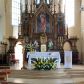 Zdjęcie nr 1: Drewniany ołtarz główny w Osieku uzyskał formę przyściennej, jednokondygnacyjnej, architektonicznej struktury trójosiowej z bramkami. Drewniana mensa z portatylem wspiera się na prostopadłościennym stipesie ołtarzowym. Jego fronton artykułują kolumienki o gładkich trzonach i złoconych podstawach oraz kapitelach z „gotyckim” akantem. Pomiędzy nimi w polach usytuowano złocone płyciny w kształcie leżącego prostokąta zamkniętego łukiem trójlistnym ściętym. Wypełniono je płaskorzeźbionymi, polichromowanymi przedstawieniami ofiary Abrahama, Ostatniej Wieczerzy oraz ofiary Melchizedeka. Na mensie ustawiono prostopadłościenne tabernakulum pancerne z tronem wystawienia w formie oktagonalnej kapliczki ujętej ustawionymi ukośnie kolumienkami o skręconych trzonach zwieńczonej wimpergami, wypełnionymi złoconym „gotyckim” akantem oraz pinaklami. Na podniebiu baldachimu wyobrażono gołębicę Ducha Świętego na tle glorii promienistej oraz lilie heraldyczne w ukośnej kratownicy. Tron wystawienia ujęty został polichromowanymi postaciami klęczących aniołów, ponad którymi rozpięto ostrołukowy baldachim z wimpergami i pinaklami wsparty na gotyckich półkolumienkach. Samo retabulum ustawiono na wysokim dwukondygnacyjnym cokole artykułowanym w pierwszej kondygnacji wąskimi, ostołukowymi płycinami wypełnionymi dekoracją pseudomaswerkową. Natomiast na drugim poziomie znalazły się gotyckie kolumienki na wysokich cokołach dźwigające przecinające się łuki wypełnione dekoracją pseudomaswerkową w formie trójliści. W polach pomiędzy kolumienkami zastosowano symetryczny ornament utworzony z gotyckiego akantu, płaskorzeźbione i złocone przedstawienia aniołów, winne grona, kłosy oraz czwórliście. Wznoszącą się na cokole nastawę artykułowano „gotyckimi” kolumnami o gładkich trzonach i złoconych korynckich kapitelach. Dodatkowo w osi środkowej kolumny w połowie wysokości ozdobiono akantowymi talerzykami. Pole środkowe retabulum uzyskało kształt stojącego prostokąta zamkniętego łukiem trójlistnym, w którym zainstalowano figurę Chrystusa Bolesnego, a na zasuwach obraz św. Andrzeja oraz obraz Matki Boskiej Niepokalanie Poczętej. Ujmuje je profilowane, złocone obramienie zamknięte ostrołukową wimpergą ujęty po bokach dwoma kondygnacjami zamkniętych trójlistnie nisz mieszczących polichromowane figury: św. Łukasza, św. Jana Ewangelisty, św. Mateusza i św. Marka. W osiach bocznych nastawy ustawiono w niszach zamkniętych trójlistnie polichromowane figury św. Piotra i św. Pawła na tle malowanego astwerku oraz złotych gwiazd w podniebiu. Rozbudowane, ażurowe zwieńczenie ołtarza uzyskało formę licznych pinakli dekorowanych złoconymi czołgankami, otaczającymi ażurową edikulę zwieńczoną krzyżem. Dodatkowo w osi środkowej ustawiono polichromowane figury aniołów trzymających banderole. Bramki ołtarzowe uzyskały formę ostrołukowych przejść dekorowanych rzeźbionym maswerskiem z motywami trójliścia. Całą struktura nastawy jest bejcowana i lakierowana w kolorze ciemnego brązu.Natomiast załamania profili architektonicznych malowane zostały na czerwono i błękitno. Płaskorzeźbione ornamenty pozłocone, zaś figury otrzymały pełne polichromowanie.