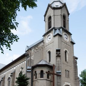 Zdjęcie nr 1: Prezbiterium jest węższe od nawy, zamknięte trójbocznie, oddziela je tęcza o łuku półkolistym z napisem „EGO SUM VIA VERITAS ET VITA”. Od zachodu chór na dwóch filarach, zamknięty balustradą dekorowaną płycinami. Ściany wnętrza dzielą pilastry podtrzymujące gurty sklepienia i łuki arkad, a dekoruje polichromia ze scenami biblijnymi i wizerunkami świętych. Sklepienie krzyżowo-żebrowe. Ściany przeprute oknami – prezbiterium dwoma, transept sześcioma, nawa czterema, kolejne w wieży i rotundach. Niemal wszystkie  kształcie stojącego prostokąta zamkniętego łukiem pełnym, kolejne; większość wypełniają witraże. Główne wejście przez korpus wieżowy od zachodu, kolejne do obu ramion transeptu i przybudówek. Fasada wieżowa, z wejściem przez portal z archiwoltami, z kolumienkami po bokach, ujęty ściśle szerokimi , ustawionymi skośnie szkarpami zwieńczonymi tympanonami i kapnikami. Powyżej portalu trójdzielne okno w kształcie smukłych, stojących prostokątów, a nad nim prostokątne zamknięte łukiem pełnym. Wyżej tarcza zegara w szerokiej ramie, zamontowana w szczycie. Wyżej wieża przechodzi w ośmiobok o czterech ścianach zwieńczonych ostrołukowo i przeprutych oknami i ściętych narożach między nimi.  Masyw wieży flankują wieloboczne ćwierćrotundy z arkadami ujętymi kolumientami w górnej partii i dekoracją kostkową pod linią dachu.  Z zewnątrz bryła kościoła jest rozczłonkowana, o ścianach wspartych przyporami z kapnikami i fryzem arkadkowym pod linią dachu. Wszystkie dachy blaszane; nad nawą, transeptem i przybudówkami dwuspadowe, nad prezbiterium zamknięty wielobocznie. Wieżę przykrywa wieloboczny, wyjątkowo wysoki dach namiotowy, nad rotundami wieloboczne.  Całe wyposażenie jest spójne, powstało około 1900 roku i zostało wykonane w stylu neogotyckim. 