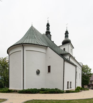 Zdjęcie nr 5: Kościół usytuowany jest w centrum miejscowości, na północny-zachód od drogi prowadzącej z Orawki do Spytkowic. Plac kościelny otoczony jest żeliwnym płotem na kamiennej podmurówce. Główne wejście prowadzi od strony zachodniej; drugie, mniejsze od strony południowej. 

Kościół orientowany, jednonawowy z emporami w części zachodniej, podtrzymywanymi przez arkady, które tworzą dodatkowe przejścia; prezbiterium krótkie i węższe od nawy, zamknięte półkoliście, od północny przylega do niego niewielka zakrystia. Główne wejście do kościoła znajduje się od strony zachodniej przez czworoboczny przedsionek, nad którym wznosi się wieża, drugie wejście przez kruchtę od strony południowej nawy. Kościół jest oświetlony przez  sześć podłużnych okien zamkniętych półkoliście oraz dwóch takich samych w prezbiterium, ponadto na wschodniej ścianie prezbiterium dwa niewielkie, okrągłe otwory okienne. Wnętrze artykułowane jest pilastrami wspierającymi gurty sklepienne, w ostatnim wschodnim przęśle nawy półkoliste arkady tworzące pseudotransept. Chór muzyczny wsparty na trzech arkadach, zamkniętych łukiem odcinkowym, analogiczne dwie pary arkad wspierają empory po bokach nawy. Sklepienie w nawie trójprzęsłowe, kolebkowe na gurtach, w prezbiterium jednoprzęsłowe.

Elewacja kościoła w dolnej części z kamienną okładziną, wyżej kościół tynkowany, artykułowany lizenami. Fasada zachodnia trójosiowa, w osi środkowej wysunięta do przodu trójkondygnacyjna wieża, flankowana lizenami. W drugiej kondygnacji na osiach bocznych fasady spływy flankujące wieżę, za którymi schowany jest dach nad nawą. Wieża nakryta hełmem baniastym z latarnią. Na zakończeniu nawy wieżyczka na sygnaturkę, nakryta analogicznym, mniejszym hełmem z latarnią. Dach nad nawą dwuspadowy, nad prezbiterium, nad kruchtą siodłowy. Na przyczółku kruchty umieszczona jest w głębokiej wnęce, zamkniętej łukiem odcinkowym rzeźba Matki Boskiej z Dzieciątkiem, a nad wejściem zachodnim do świątyni rzeźba św. Wojciecha.



