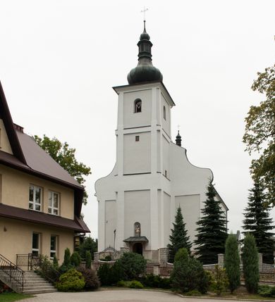Zdjęcie nr 4: Kościół usytuowany jest w centrum miejscowości, na północny-zachód od drogi prowadzącej z Orawki do Spytkowic. Plac kościelny otoczony jest żeliwnym płotem na kamiennej podmurówce. Główne wejście prowadzi od strony zachodniej; drugie, mniejsze od strony południowej. 

Kościół orientowany, jednonawowy z emporami w części zachodniej, podtrzymywanymi przez arkady, które tworzą dodatkowe przejścia; prezbiterium krótkie i węższe od nawy, zamknięte półkoliście, od północny przylega do niego niewielka zakrystia. Główne wejście do kościoła znajduje się od strony zachodniej przez czworoboczny przedsionek, nad którym wznosi się wieża, drugie wejście przez kruchtę od strony południowej nawy. Kościół jest oświetlony przez  sześć podłużnych okien zamkniętych półkoliście oraz dwóch takich samych w prezbiterium, ponadto na wschodniej ścianie prezbiterium dwa niewielkie, okrągłe otwory okienne. Wnętrze artykułowane jest pilastrami wspierającymi gurty sklepienne, w ostatnim wschodnim przęśle nawy półkoliste arkady tworzące pseudotransept. Chór muzyczny wsparty na trzech arkadach, zamkniętych łukiem odcinkowym, analogiczne dwie pary arkad wspierają empory po bokach nawy. Sklepienie w nawie trójprzęsłowe, kolebkowe na gurtach, w prezbiterium jednoprzęsłowe.

Elewacja kościoła w dolnej części z kamienną okładziną, wyżej kościół tynkowany, artykułowany lizenami. Fasada zachodnia trójosiowa, w osi środkowej wysunięta do przodu trójkondygnacyjna wieża, flankowana lizenami. W drugiej kondygnacji na osiach bocznych fasady spływy flankujące wieżę, za którymi schowany jest dach nad nawą. Wieża nakryta hełmem baniastym z latarnią. Na zakończeniu nawy wieżyczka na sygnaturkę, nakryta analogicznym, mniejszym hełmem z latarnią. Dach nad nawą dwuspadowy, nad prezbiterium, nad kruchtą siodłowy. Na przyczółku kruchty umieszczona jest w głębokiej wnęce, zamkniętej łukiem odcinkowym rzeźba Matki Boskiej z Dzieciątkiem, a nad wejściem zachodnim do świątyni rzeźba św. Wojciecha.



