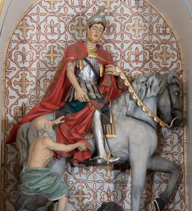 Zdjęcie nr 7: Ołtarz przyścienny, architektoniczny, jednoosiowy, jednokondygnacyjny ze zwieńczeniem, z bramkami. Mensa drewniana, prostopadłościenna zwężająca się ku dołowi. Antepedium z dekoracją płycinową wypełnioną marmoryzacją; w centrum medalion mieszczący złocony, równoramienny krzyż. Tabernakulum o formach architektonicznych ujęte ustawionymi ukośnie, zdwojonymi kolumienkami o kanelowanych trzonach dźwigającymi odcinki pełnego belkowania. W części centralnej zwieńczenie w formie gzymsu wygiętego w łuk wyniesiony. Na szczycie prosty tron wystawienia. Drzwiczki metalowe, fakturowane z przedstawieniem krzyża i monogramem XP na skrzyżowaniu ramion, w otoczeniu kłosów oraz winnych gron. Nad drzwiczkami odlewany medalion z przedstawieniem Baranka na tle krzyża. 

Nastawa ustawiona na wysokim, zdwojonym cokole o licach wypełnionych płycinami z marmoryzacją oraz rzeźbionym, złoconym akantem. Kondygnacja ujęta zdwojonymi, złoconymi, kompozytowymi kolumnami, przed którymi znajdują się wysunięte postumenty z figurami węgierskich królów: św. Stefana po lewej stronie i św. Władysława po prawej stronie. Podpory dźwigają odcinki pełnego, przerwanego nad polem głównym belkowania z szerokim fryzem i wydatnym gzymsem dekorowanym kostkowaniem, wyniesionym w formę półkolistego łuku w zwieńczeniu. W polu głównym rzeźba św. Marcina, a na zasuwie obraz „Wizja św. Franciszka”. Kondygnacja ujęta po bokach złoconymi, akantowymi uszami oraz bramkami w formie półkolistych arkad  wspartych na kompozytowych filarach o trzonach dekorowanych podłużnymi płycinami wypełnionymi marmoryzacją. Na osi bramek cokoły w formie impostów, na których ustawione są figury: św. Piotra po lewej stronie i św. Pawła po prawej. W zwieńczeniu tondo z płaskorzeźbą Trójcy Świętej. W podłuczu zamykającej arkady wolutowe, złocone konsolki. Całość zamknięta złoconym krzyżem ujętym ażurową dekoracją z akantu. Po bokach, na odcinkach belkowania pełnoplastyczne, polichromowane figury klęczących aniołów. Struktura malowana na jasny beż, płyciny wypełnione marmoryzacją w odcieniach łososiowego różu, ornamentyka oraz załamania profili architektonicznych złocone, detale srebrzone.