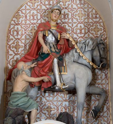 Zdjęcie nr 8: Ołtarz przyścienny, architektoniczny, jednoosiowy, jednokondygnacyjny ze zwieńczeniem, z bramkami. Mensa drewniana, prostopadłościenna zwężająca się ku dołowi. Antepedium z dekoracją płycinową wypełnioną marmoryzacją; w centrum medalion mieszczący złocony, równoramienny krzyż. Tabernakulum o formach architektonicznych ujęte ustawionymi ukośnie, zdwojonymi kolumienkami o kanelowanych trzonach dźwigającymi odcinki pełnego belkowania. W części centralnej zwieńczenie w formie gzymsu wygiętego w łuk wyniesiony. Na szczycie prosty tron wystawienia. Drzwiczki metalowe, fakturowane z przedstawieniem krzyża i monogramem XP na skrzyżowaniu ramion, w otoczeniu kłosów oraz winnych gron. Nad drzwiczkami odlewany medalion z przedstawieniem Baranka na tle krzyża. 

Nastawa ustawiona na wysokim, zdwojonym cokole o licach wypełnionych płycinami z marmoryzacją oraz rzeźbionym, złoconym akantem. Kondygnacja ujęta zdwojonymi, złoconymi, kompozytowymi kolumnami, przed którymi znajdują się wysunięte postumenty z figurami węgierskich królów: św. Stefana po lewej stronie i św. Władysława po prawej stronie. Podpory dźwigają odcinki pełnego, przerwanego nad polem głównym belkowania z szerokim fryzem i wydatnym gzymsem dekorowanym kostkowaniem, wyniesionym w formę półkolistego łuku w zwieńczeniu. W polu głównym rzeźba św. Marcina, a na zasuwie obraz „Wizja św. Franciszka”. Kondygnacja ujęta po bokach złoconymi, akantowymi uszami oraz bramkami w formie półkolistych arkad  wspartych na kompozytowych filarach o trzonach dekorowanych podłużnymi płycinami wypełnionymi marmoryzacją. Na osi bramek cokoły w formie impostów, na których ustawione są figury: św. Piotra po lewej stronie i św. Pawła po prawej. W zwieńczeniu tondo z płaskorzeźbą Trójcy Świętej. W podłuczu zamykającej arkady wolutowe, złocone konsolki. Całość zamknięta złoconym krzyżem ujętym ażurową dekoracją z akantu. Po bokach, na odcinkach belkowania pełnoplastyczne, polichromowane figury klęczących aniołów. Struktura malowana na jasny beż, płyciny wypełnione marmoryzacją w odcieniach łososiowego różu, ornamentyka oraz załamania profili architektonicznych złocone, detale srebrzone.