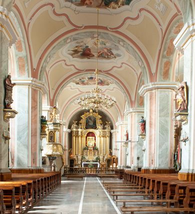 Zdjęcie nr 20: Kościół usytuowany jest w centrum miejscowości na północ od głównej drogi. Na plac kościelny prowadzi główne wejście od strony wschodniej. Świątynia skierowana jest na północ, założona na planie prostokąta z wieżą w fasadzie z prezbiterium zamkniętym trójbocznie, węższym od nawy. Za prezbiterium dobudowana jest kaplica na planie prostokąta, a od zachodu zakrystia. Główne wejście do kościoła znajduje się od strony południowej. 

Wnętrze trójnawowe, halowe, czteroprzęsłowe; nawy oddzielone arkadami na opliastrowanych filarach o wklęsłych narożnikach wspierających sklepienie żaglaste na gurtach. Chór muzyczny wsparty na trzech arkadach filarowych. Balustrada na rzucie wklęsło-wypukłym z uskokami. Wnętrze nawy jest oświetlone przez dziesięć, niskich, zamkniętych półkoliście okien, w prezbiterium cztery analogiczne okna. 

Fasada z ryzalitem w osi środkowej, ujętym zdwojonymi pilastrami, zwieńczonym przerwanym przyczółkiem, na osi portal i balkon z półkoliście zamkniętym oknem. W szczycie fasady drugi przyczółek, w polu monogram maryjny, a poniżej napis: „AVE MARIA GRATIA PLENA DOMINVS TECTVM”. Wyżej na osi czworoboczna wieża, opięta pilastrami w narożach, zwieńczona baniastym hełmem z latarnią. Korpus nawowy o zaokrąglonych narożnikach z podziałami ramowymi i oknami termalnymi. Prezbiterium i kaplica opięte szkarpami. Nad prezbiterium i nawą oddzielne dachy, dwuspadowe. 
