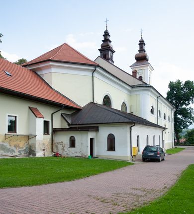 Zdjęcie nr 16: Kościół usytuowany jest w centrum miejscowości na północ od głównej drogi. Na plac kościelny prowadzi główne wejście od strony wschodniej. Świątynia skierowana jest na północ, założona na planie prostokąta z wieżą w fasadzie z prezbiterium zamkniętym trójbocznie, węższym od nawy. Za prezbiterium dobudowana jest kaplica na planie prostokąta, a od zachodu zakrystia. Główne wejście do kościoła znajduje się od strony południowej. 

Wnętrze trójnawowe, halowe, czteroprzęsłowe; nawy oddzielone arkadami na opliastrowanych filarach o wklęsłych narożnikach wspierających sklepienie żaglaste na gurtach. Chór muzyczny wsparty na trzech arkadach filarowych. Balustrada na rzucie wklęsło-wypukłym z uskokami. Wnętrze nawy jest oświetlone przez dziesięć, niskich, zamkniętych półkoliście okien, w prezbiterium cztery analogiczne okna. 

Fasada z ryzalitem w osi środkowej, ujętym zdwojonymi pilastrami, zwieńczonym przerwanym przyczółkiem, na osi portal i balkon z półkoliście zamkniętym oknem. W szczycie fasady drugi przyczółek, w polu monogram maryjny, a poniżej napis: „AVE MARIA GRATIA PLENA DOMINVS TECTVM”. Wyżej na osi czworoboczna wieża, opięta pilastrami w narożach, zwieńczona baniastym hełmem z latarnią. Korpus nawowy o zaokrąglonych narożnikach z podziałami ramowymi i oknami termalnymi. Prezbiterium i kaplica opięte szkarpami. Nad prezbiterium i nawą oddzielne dachy, dwuspadowe. 
