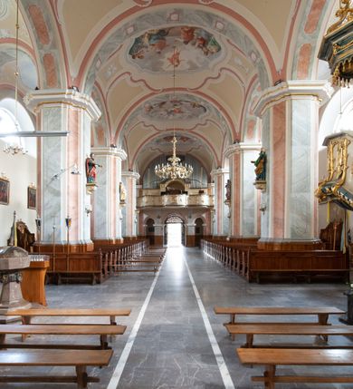 Zdjęcie nr 17: Kościół usytuowany jest w centrum miejscowości na północ od głównej drogi. Na plac kościelny prowadzi główne wejście od strony wschodniej. Świątynia skierowana jest na północ, założona na planie prostokąta z wieżą w fasadzie z prezbiterium zamkniętym trójbocznie, węższym od nawy. Za prezbiterium dobudowana jest kaplica na planie prostokąta, a od zachodu zakrystia. Główne wejście do kościoła znajduje się od strony południowej. 

Wnętrze trójnawowe, halowe, czteroprzęsłowe; nawy oddzielone arkadami na opliastrowanych filarach o wklęsłych narożnikach wspierających sklepienie żaglaste na gurtach. Chór muzyczny wsparty na trzech arkadach filarowych. Balustrada na rzucie wklęsło-wypukłym z uskokami. Wnętrze nawy jest oświetlone przez dziesięć, niskich, zamkniętych półkoliście okien, w prezbiterium cztery analogiczne okna. 

Fasada z ryzalitem w osi środkowej, ujętym zdwojonymi pilastrami, zwieńczonym przerwanym przyczółkiem, na osi portal i balkon z półkoliście zamkniętym oknem. W szczycie fasady drugi przyczółek, w polu monogram maryjny, a poniżej napis: „AVE MARIA GRATIA PLENA DOMINVS TECTVM”. Wyżej na osi czworoboczna wieża, opięta pilastrami w narożach, zwieńczona baniastym hełmem z latarnią. Korpus nawowy o zaokrąglonych narożnikach z podziałami ramowymi i oknami termalnymi. Prezbiterium i kaplica opięte szkarpami. Nad prezbiterium i nawą oddzielne dachy, dwuspadowe. 
