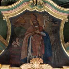 Zdjęcie nr 1: Obraz w zwieńczeniu ołtarza bocznego ma kształt stojącego prostokąta o wklęsłych bokach, ściętych narożach dolnych, zamkniętego łukiem o czterech wklęsłościach. Zawiera całopostaciowy wizerunek św. Erazma biskupa i męczennika. Święty ukazany jest w ujęciu na wprost, z głową zwróconą w trzech czwartych w prawo. Owalną twarz charakteryzują delikatne, sumarycznie opracowane rysy oraz krótki, brązowy, dwudzielny zarost. Święty ubrany jest w strój biskupi, na który składa się alba, czerwona dalmatyka i kapa z niebieską podszewką. Na głowie ma pomarańczową infułę, na piersiach pektorał. Dłonie osłaniają żółte rękawiczki z wyhaftowanymi krzyżykami. Wspartą na piersiach lewą ręką podtrzymuje pastorał, prawa, lekko zgięta w łokciu, opuszczona jest wzdłuż ciała. Głowę świętego okala promienisty nimb. Po lewej stronie kompozycji, obok św. Erazma stoi chrzcielnica, a tuż za nią anioł ze złożonymi na piersiach rękami, z gałązką palmową w dłoni. Postaci znajdują się na pokładzie statku. Po prawej stronie widoczne są narzędzia męczeństwa św. Erazma – dwie pałki, kajdany oraz kołowrót. W górnej partii obrazu po prawej stronie widoczny jest przelatujący kruk mający w dziobie chleb, po lewej trójkąt Trójcy Świętej z trzema płomieniami w narożach i napisem u dołu „FIET UT PETISTI”.  

