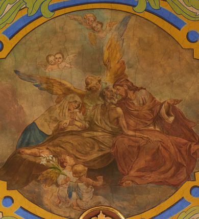 Zdjęcie nr 23: Polichromia pokrywa zarówno powierzchnię ścian, jak i sklepień kościoła, jednak zdecydowanie bardziej dekoracyjne motywy pojawiają się w górnych partiach murów. Dominuje stylizowana ornamentyka roślinna na błękitnym tle, utrzymana w jasnych, żywych tonacjach zróżnicowanych kolorów. Szerokie bordiury o tworzących je fantazyjnych formach i roślinności ujmują niewielkich rozmiarów sceny figuralne umiejscowione pośrodku sklepienia każdego z przęseł kościoła. Kompozycje, o zbliżonych do owalu kształtach przedstawiają: Śmierć św. Józefa w ostatnim przęśle nawy, Ukoronowanie Matki Boskiej na przecięciu nawy z transeptem oraz Wniebowzięcie Najświętszej Marii Panny w przęśle prezbiterium. W konsze absydy ukazana jest scena adoracji kielicha eucharystycznego przez anioły o tęczowych skrzydłach, ubrane w barwne, wzorzyste szaty. Po lewej stronie kościoła, na ścianie transeptu jest ukazana na tle pejzażu scena Chrztu Jezusa. 