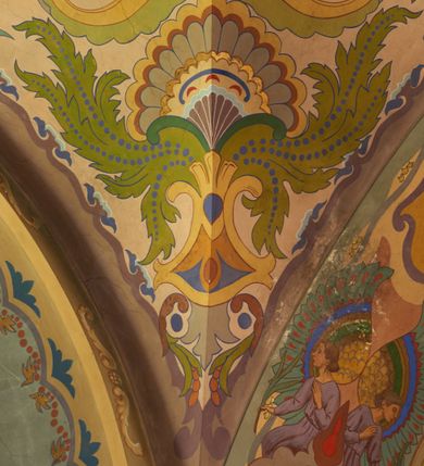 Zdjęcie nr 12: Polichromia pokrywa zarówno powierzchnię ścian, jak i sklepień kościoła, jednak zdecydowanie bardziej dekoracyjne motywy pojawiają się w górnych partiach murów. Dominuje stylizowana ornamentyka roślinna na błękitnym tle, utrzymana w jasnych, żywych tonacjach zróżnicowanych kolorów. Szerokie bordiury o tworzących je fantazyjnych formach i roślinności ujmują niewielkich rozmiarów sceny figuralne umiejscowione pośrodku sklepienia każdego z przęseł kościoła. Kompozycje, o zbliżonych do owalu kształtach przedstawiają: Śmierć św. Józefa w ostatnim przęśle nawy, Ukoronowanie Matki Boskiej na przecięciu nawy z transeptem oraz Wniebowzięcie Najświętszej Marii Panny w przęśle prezbiterium. W konsze absydy ukazana jest scena adoracji kielicha eucharystycznego przez anioły o tęczowych skrzydłach, ubrane w barwne, wzorzyste szaty. Po lewej stronie kościoła, na ścianie transeptu jest ukazana na tle pejzażu scena Chrztu Jezusa. 