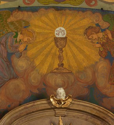 Zdjęcie nr 27: Polichromia pokrywa zarówno powierzchnię ścian, jak i sklepień kościoła, jednak zdecydowanie bardziej dekoracyjne motywy pojawiają się w górnych partiach murów. Dominuje stylizowana ornamentyka roślinna na błękitnym tle, utrzymana w jasnych, żywych tonacjach zróżnicowanych kolorów. Szerokie bordiury o tworzących je fantazyjnych formach i roślinności ujmują niewielkich rozmiarów sceny figuralne umiejscowione pośrodku sklepienia każdego z przęseł kościoła. Kompozycje, o zbliżonych do owalu kształtach przedstawiają: Śmierć św. Józefa w ostatnim przęśle nawy, Ukoronowanie Matki Boskiej na przecięciu nawy z transeptem oraz Wniebowzięcie Najświętszej Marii Panny w przęśle prezbiterium. W konsze absydy ukazana jest scena adoracji kielicha eucharystycznego przez anioły o tęczowych skrzydłach, ubrane w barwne, wzorzyste szaty. Po lewej stronie kościoła, na ścianie transeptu jest ukazana na tle pejzażu scena Chrztu Jezusa. 