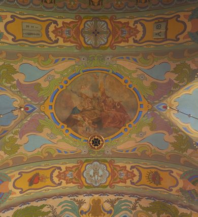 Zdjęcie nr 20: Polichromia pokrywa zarówno powierzchnię ścian, jak i sklepień kościoła, jednak zdecydowanie bardziej dekoracyjne motywy pojawiają się w górnych partiach murów. Dominuje stylizowana ornamentyka roślinna na błękitnym tle, utrzymana w jasnych, żywych tonacjach zróżnicowanych kolorów. Szerokie bordiury o tworzących je fantazyjnych formach i roślinności ujmują niewielkich rozmiarów sceny figuralne umiejscowione pośrodku sklepienia każdego z przęseł kościoła. Kompozycje, o zbliżonych do owalu kształtach przedstawiają: Śmierć św. Józefa w ostatnim przęśle nawy, Ukoronowanie Matki Boskiej na przecięciu nawy z transeptem oraz Wniebowzięcie Najświętszej Marii Panny w przęśle prezbiterium. W konsze absydy ukazana jest scena adoracji kielicha eucharystycznego przez anioły o tęczowych skrzydłach, ubrane w barwne, wzorzyste szaty. Po lewej stronie kościoła, na ścianie transeptu jest ukazana na tle pejzażu scena Chrztu Jezusa. 