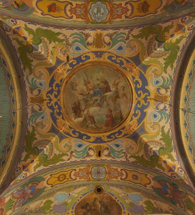 Zdjęcie nr 36: Polichromia pokrywa zarówno powierzchnię ścian, jak i sklepień kościoła, jednak zdecydowanie bardziej dekoracyjne motywy pojawiają się w górnych partiach murów. Dominuje stylizowana ornamentyka roślinna na błękitnym tle, utrzymana w jasnych, żywych tonacjach zróżnicowanych kolorów. Szerokie bordiury o tworzących je fantazyjnych formach i roślinności ujmują niewielkich rozmiarów sceny figuralne umiejscowione pośrodku sklepienia każdego z przęseł kościoła. Kompozycje, o zbliżonych do owalu kształtach przedstawiają: Śmierć św. Józefa w ostatnim przęśle nawy, Ukoronowanie Matki Boskiej na przecięciu nawy z transeptem oraz Wniebowzięcie Najświętszej Marii Panny w przęśle prezbiterium. W konsze absydy ukazana jest scena adoracji kielicha eucharystycznego przez anioły o tęczowych skrzydłach, ubrane w barwne, wzorzyste szaty. Po lewej stronie kościoła, na ścianie transeptu jest ukazana na tle pejzażu scena Chrztu Jezusa. 