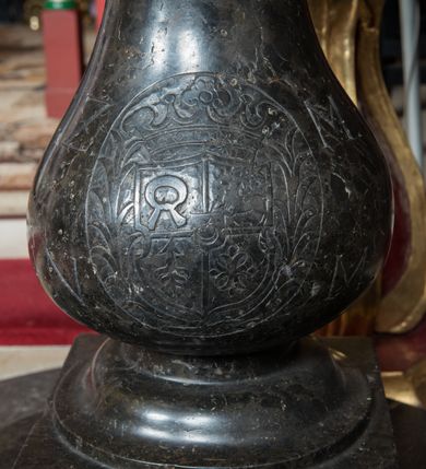 Zdjęcie nr 5: Na dwustopniowej i okrągłej podstawie oraz prostopadłościennym cokole niewielka stopa z trzonem w typie balustradowej lalki podtrzymującej półkulistą czarę o powierzchni imitującej puklowanie z wklęską i zaoblonym brzegiem. Na trzonie w owalnym polu ryta pięciopolowa tarcza czterodzielna w krzyż z polem sercowym ujęta labrami i zwieńczona koroną otwartą. W polu sercowym godło herbu Leliwa, w kolejnych polach godła herbów Nałęcz, Brochwicz, Niesobia i Gierałt. Po bokach owalnego pola sygle „Z / M / N / M”. Pokrywa spłaszczona, dwustrefowa, z wąskim trzonem o lekko wklęsłych bokach zwieńczonym spłaszczoną, cylindryczną opaską z kanelurami i perełkowaniem, zakończonym złoconym kwiatonem. Pokrywa w kolorze różowym ze złoconymi profilami, kanelurami, perełkowaniem i kwiatonem.   