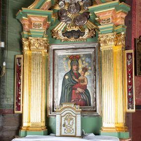 Zdjęcie nr 1: Ołtarz drewniany, ustawiony na jednostopniowej podstawie, jednokondygnacyjny, jednoosiowy ze zwieńczeniem. Ołtarz sarkofagowy z drewnianą mensą i marmurowym portatylem. Antepedium marmoryzowane, z prostokątnym polem z kartuszem i monogramem Marii.

Część środkowa nastawy ujęta parą zdwojonych filarów skierowanych do wewnątrz o kanelowanych trzonach i korynckich kapitelach, podtrzymujących zdwojone imposty i przerwany, wolutowy przyczółek. W polu wnęka w formie stojącego prostokąta z profilowaną ramą, wewnątrz obraz Matki Boskiej Śnieżnej ujęty drugą ramą; nad nim kartusz z napisem „Św(ięta) / MARIO MÓDL SIĘ / ZA NAMI”. W polu zwieńczenia, pomiędzy impostami gołębica Ducha Świętego w otoku z obłoków i glorii promienistej, nad nią trzy uskrzydlone główki anielskie. Ołtarz ujęty wąskimi gablotami na wota. Struktura polichromowana na zielono, z detalami marmoryzowanymi w kolorze jasnobrązowo-beżowym oraz złoconymi filarami, profilami i ornamentyką.