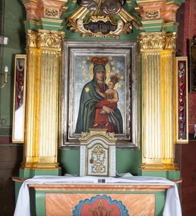 Zdjęcie nr 2: Ołtarz drewniany, ustawiony na jednostopniowej podstawie, jednokondygnacyjny, jednoosiowy ze zwieńczeniem. Ołtarz sarkofagowy z drewnianą mensą i marmurowym portatylem. Antepedium marmoryzowane, z prostokątnym polem z kartuszem i monogramem Marii.

Część środkowa nastawy ujęta parą zdwojonych filarów skierowanych do wewnątrz o kanelowanych trzonach i korynckich kapitelach, podtrzymujących zdwojone imposty i przerwany, wolutowy przyczółek. W polu wnęka w formie stojącego prostokąta z profilowaną ramą, wewnątrz obraz Matki Boskiej Śnieżnej ujęty drugą ramą; nad nim kartusz z napisem „Św(ięta) / MARIO MÓDL SIĘ / ZA NAMI”. W polu zwieńczenia, pomiędzy impostami gołębica Ducha Świętego w otoku z obłoków i glorii promienistej, nad nią trzy uskrzydlone główki anielskie. Ołtarz ujęty wąskimi gablotami na wota. Struktura polichromowana na zielono, z detalami marmoryzowanymi w kolorze jasnobrązowo-beżowym oraz złoconymi filarami, profilami i ornamentyką.