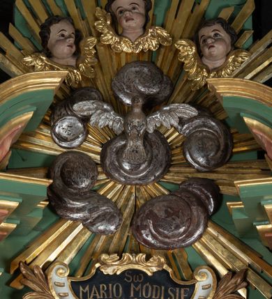 Zdjęcie nr 4: Ołtarz drewniany, ustawiony na jednostopniowej podstawie, jednokondygnacyjny, jednoosiowy ze zwieńczeniem. Ołtarz sarkofagowy z drewnianą mensą i marmurowym portatylem. Antepedium marmoryzowane, z prostokątnym polem z kartuszem i monogramem Marii.

Część środkowa nastawy ujęta parą zdwojonych filarów skierowanych do wewnątrz o kanelowanych trzonach i korynckich kapitelach, podtrzymujących zdwojone imposty i przerwany, wolutowy przyczółek. W polu wnęka w formie stojącego prostokąta z profilowaną ramą, wewnątrz obraz Matki Boskiej Śnieżnej ujęty drugą ramą; nad nim kartusz z napisem „Św(ięta) / MARIO MÓDL SIĘ / ZA NAMI”. W polu zwieńczenia, pomiędzy impostami gołębica Ducha Świętego w otoku z obłoków i glorii promienistej, nad nią trzy uskrzydlone główki anielskie. Ołtarz ujęty wąskimi gablotami na wota. Struktura polichromowana na zielono, z detalami marmoryzowanymi w kolorze jasnobrązowo-beżowym oraz złoconymi filarami, profilami i ornamentyką.