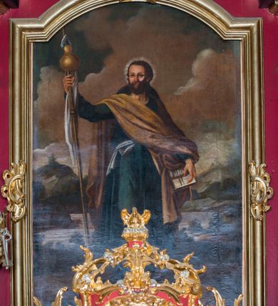 Zdjęcie nr 4: Obraz w formie stojącego prostokąta. W centrum kompozycji ukazany w całej postaci św. Jakub Apostoł na tle rozległego pejzażu. Święty przedstawiony frontalnie, z głową skierowaną w prawo, w lewej opuszczonej ręce trzyma otwartą księgę z napisem „ET / IN IESUM / CHRISTVM / FILIVM / EIVS / VNICVM /DOMINVM / NOSTRVM”, w prawej, uniesionej ma drewnianą laskę z białą szarfą i zawieszonym bukłakiem. Święty został ukazany jako dojrzały mężczyzna o pociągłej twarzy, migdałowatych, ciemnych oczach, szerokim nosie i pełnych ustach; okolonej gęstą brodą i krótkimi ciemnobrązowymi włosami. Wokół głowy nimb promienisty. Ubrany jest w ciemnoniebieską tunikę sięgającą poniżej kolan, przewiązaną w talii szarfą, żółty płaszcz przerzucony diagonalnie z prawego ramienia na lewe przedramię, na plecy ma zarzucony kapelusz pielgrzymi, a na nogach wysokie buty. W tle górzysty pejzaż z rozległym jeziorem, ponad nim błękitne niebo wypełnione biało-różowymi, gęstymi obłokami. 


