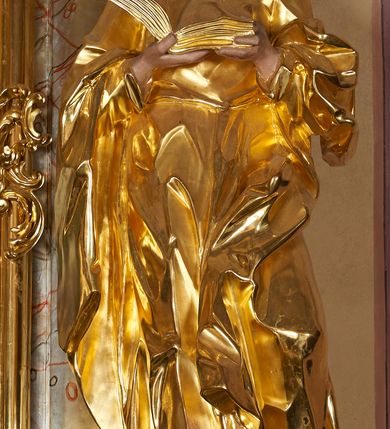 Zdjęcie nr 5: Nastawa ołtarzowa architektoniczna, jednoosiowa, jednokondygnacyjna ze zwieńczeniem. Mensa drewniana o profilowanej krawędzi. Ołtarz  sarkofagowy, na profilowanym cokole; na froncie intarsjowany wzór geometryczny. Kondygnacja ustawiona na cokole, ujęta parą zdwojonych filarów o kapitelach kompozytowych. Podpory dźwigają pełne belkowanie, wyłamane na ich osi, o wklęsło-wypukłym fryzie i silnie wysuniętym gzymsie oraz przerwany wolutowy przyczółek. W polu środkowym profilowana rama w formie stojącego prostokąta zamkniętego łukiem segmentowym nadwieszonym z uskokiem, z obrazem „Zwiastowanie”. Przed filarami, na wklęsło-wypukłych postumentach dwie figury niezidentyfikowanych świętych. Zwieńczenie w formie leżącego prostokąta ujętego spływami wolutowymi, zamkniętego falistym gzymsem przechodzącym w zwrócone przeciwstawnie woluty. W polu rama o fantazyjnej formie zbliżonej do trójkąta z obrazem „Nawiedzenie św. Elżbiety”. Trzony filarów dekorowane kampanulami. W polu środkowym w przyłuczach ornament rocaille'owy. Rama obrazu na dłuższych bokach zdobiona rocaille'm. Nad polem środkowym na belkowaniu rocaille'owy kartusz z napisem w polu „Ave Maria gratia / Plena Dominus tecum / Luea. Ʌ”. W partii fryzu, na osiach podpór z trzech stron rozety. Struktura w całości laserunkowa, srebrzona, marmoryzowana; ornamentyka i profile złocone.