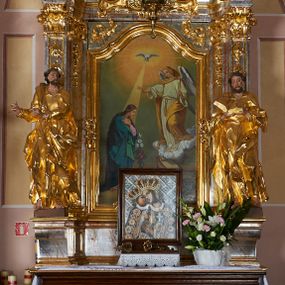 Zdjęcie nr 1: Nastawa ołtarzowa architektoniczna, jednoosiowa, jednokondygnacyjna ze zwieńczeniem. Mensa drewniana o profilowanej krawędzi. Ołtarz  sarkofagowy, na profilowanym cokole; na froncie intarsjowany wzór geometryczny. Kondygnacja ustawiona na cokole, ujęta parą zdwojonych filarów o kapitelach kompozytowych. Podpory dźwigają pełne belkowanie, wyłamane na ich osi, o wklęsło-wypukłym fryzie i silnie wysuniętym gzymsie oraz przerwany wolutowy przyczółek. W polu środkowym profilowana rama w formie stojącego prostokąta zamkniętego łukiem segmentowym nadwieszonym z uskokiem, z obrazem „Zwiastowanie”. Przed filarami, na wklęsło-wypukłych postumentach dwie figury niezidentyfikowanych świętych. Zwieńczenie w formie leżącego prostokąta ujętego spływami wolutowymi, zamkniętego falistym gzymsem przechodzącym w zwrócone przeciwstawnie woluty. W polu rama o fantazyjnej formie zbliżonej do trójkąta z obrazem „Nawiedzenie św. Elżbiety”. Trzony filarów dekorowane kampanulami. W polu środkowym w przyłuczach ornament rocaille&#039;owy. Rama obrazu na dłuższych bokach zdobiona rocaille&#039;m. Nad polem środkowym na belkowaniu rocaille&#039;owy kartusz z napisem w polu „Ave Maria gratia / Plena Dominus tecum / Luea. Ʌ”. W partii fryzu, na osiach podpór z trzech stron rozety. Struktura w całości laserunkowa, srebrzona, marmoryzowana; ornamentyka i profile złocone.