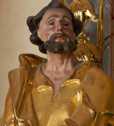 Zdjęcie nr 15: Nastawa ołtarzowa architektoniczna, jednoosiowa, jednokondygnacyjna ze zwieńczeniem. Mensa drewniana o profilowanej krawędzi. Ołtarz  sarkofagowy, na profilowanym cokole; na froncie intarsjowany wzór geometryczny. Kondygnacja ustawiona na cokole, ujęta parą zdwojonych filarów o kapitelach kompozytowych. Podpory dźwigają pełne belkowanie, wyłamane na ich osi, o wklęsło-wypukłym fryzie i silnie wysuniętym gzymsie oraz przerwany wolutowy przyczółek. W polu środkowym profilowana rama w formie stojącego prostokąta zamkniętego łukiem segmentowym nadwieszonym z uskokiem, z obrazem „Zwiastowanie”. Przed filarami, na wklęsło-wypukłych postumentach dwie figury niezidentyfikowanych świętych. Zwieńczenie w formie leżącego prostokąta ujętego spływami wolutowymi, zamkniętego falistym gzymsem przechodzącym w zwrócone przeciwstawnie woluty. W polu rama o fantazyjnej formie zbliżonej do trójkąta z obrazem „Nawiedzenie św. Elżbiety”. Trzony filarów dekorowane kampanulami. W polu środkowym w przyłuczach ornament rocaille'owy. Rama obrazu na dłuższych bokach zdobiona rocaille'm. Nad polem środkowym na belkowaniu rocaille'owy kartusz z napisem w polu „Ave Maria gratia / Plena Dominus tecum / Luea. Ʌ”. W partii fryzu, na osiach podpór z trzech stron rozety. Struktura w całości laserunkowa, srebrzona, marmoryzowana; ornamentyka i profile złocone.