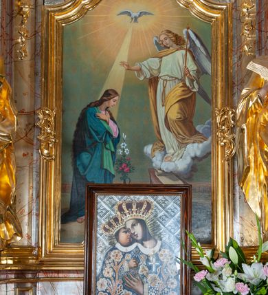 Zdjęcie nr 2: Nastawa ołtarzowa architektoniczna, jednoosiowa, jednokondygnacyjna ze zwieńczeniem. Mensa drewniana o profilowanej krawędzi. Ołtarz  sarkofagowy, na profilowanym cokole; na froncie intarsjowany wzór geometryczny. Kondygnacja ustawiona na cokole, ujęta parą zdwojonych filarów o kapitelach kompozytowych. Podpory dźwigają pełne belkowanie, wyłamane na ich osi, o wklęsło-wypukłym fryzie i silnie wysuniętym gzymsie oraz przerwany wolutowy przyczółek. W polu środkowym profilowana rama w formie stojącego prostokąta zamkniętego łukiem segmentowym nadwieszonym z uskokiem, z obrazem „Zwiastowanie”. Przed filarami, na wklęsło-wypukłych postumentach dwie figury niezidentyfikowanych świętych. Zwieńczenie w formie leżącego prostokąta ujętego spływami wolutowymi, zamkniętego falistym gzymsem przechodzącym w zwrócone przeciwstawnie woluty. W polu rama o fantazyjnej formie zbliżonej do trójkąta z obrazem „Nawiedzenie św. Elżbiety”. Trzony filarów dekorowane kampanulami. W polu środkowym w przyłuczach ornament rocaille'owy. Rama obrazu na dłuższych bokach zdobiona rocaille'm. Nad polem środkowym na belkowaniu rocaille'owy kartusz z napisem w polu „Ave Maria gratia / Plena Dominus tecum / Luea. Ʌ”. W partii fryzu, na osiach podpór z trzech stron rozety. Struktura w całości laserunkowa, srebrzona, marmoryzowana; ornamentyka i profile złocone.